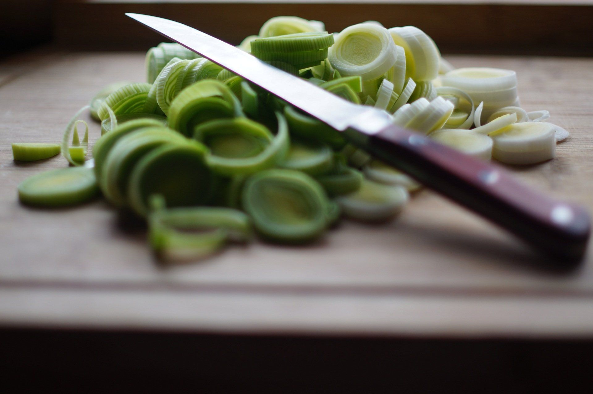 Chopped up vegitables on a  wooden cutting board.