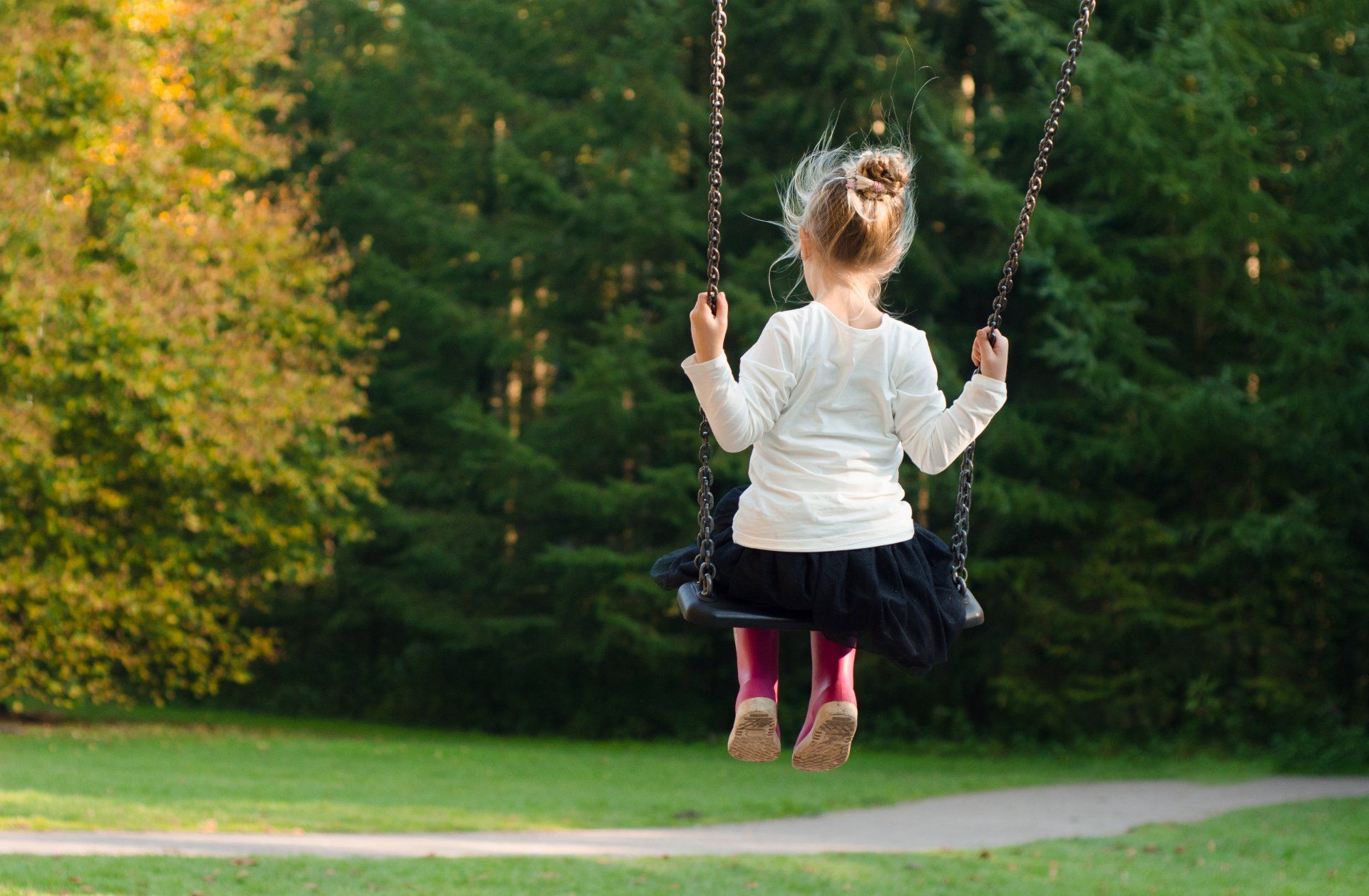 young girl sitting on a swing