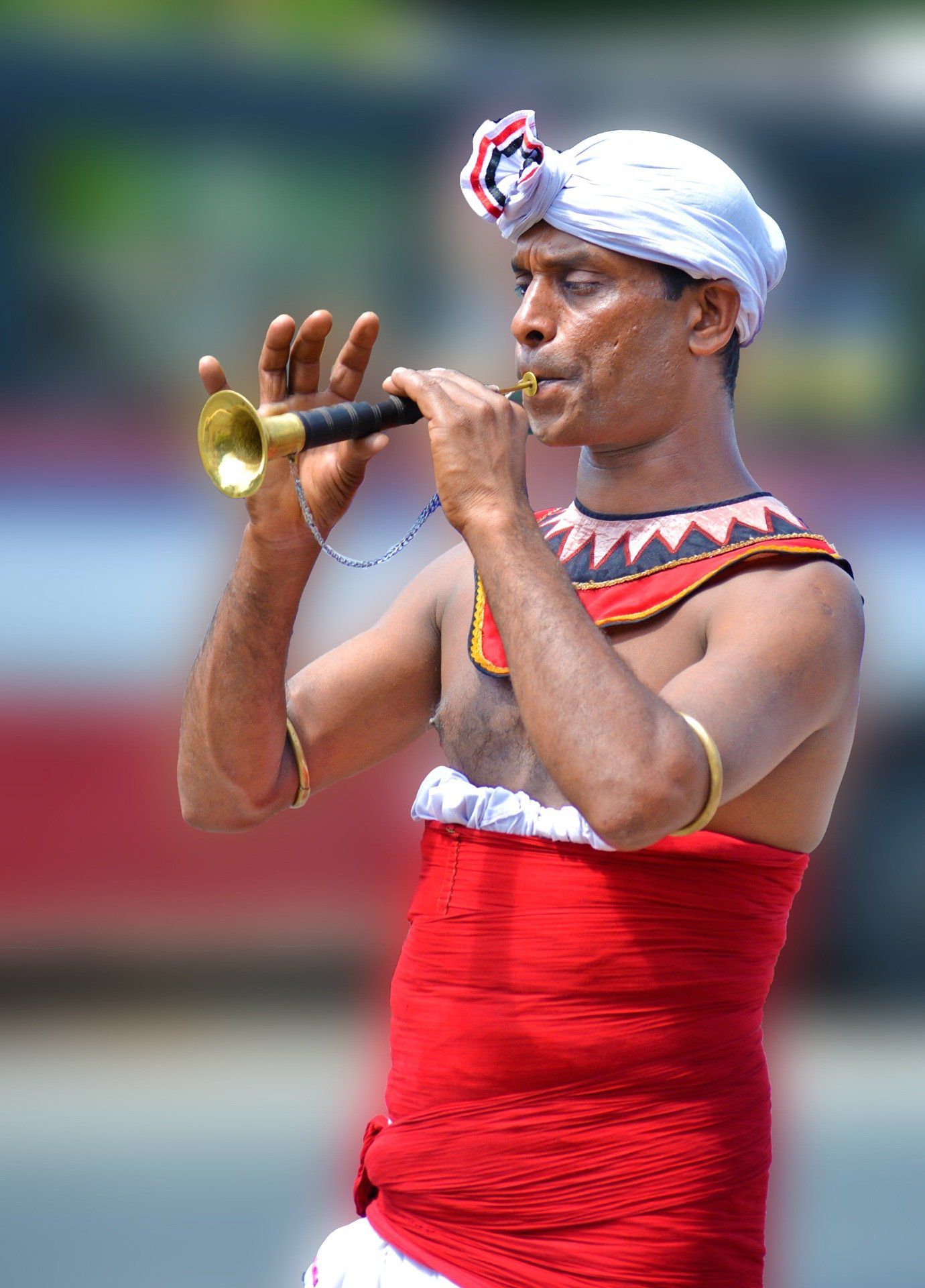 A man in a red and white outfit is playing a trumpet.