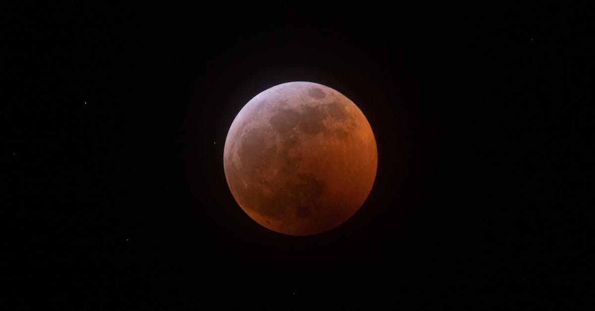 A partial lunar eclipse is visible in the night sky.