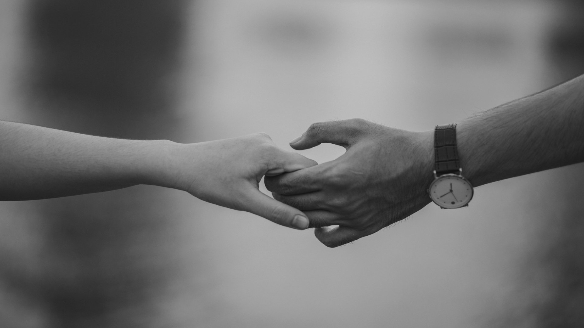 A man and a woman are holding hands in a black and white photo.