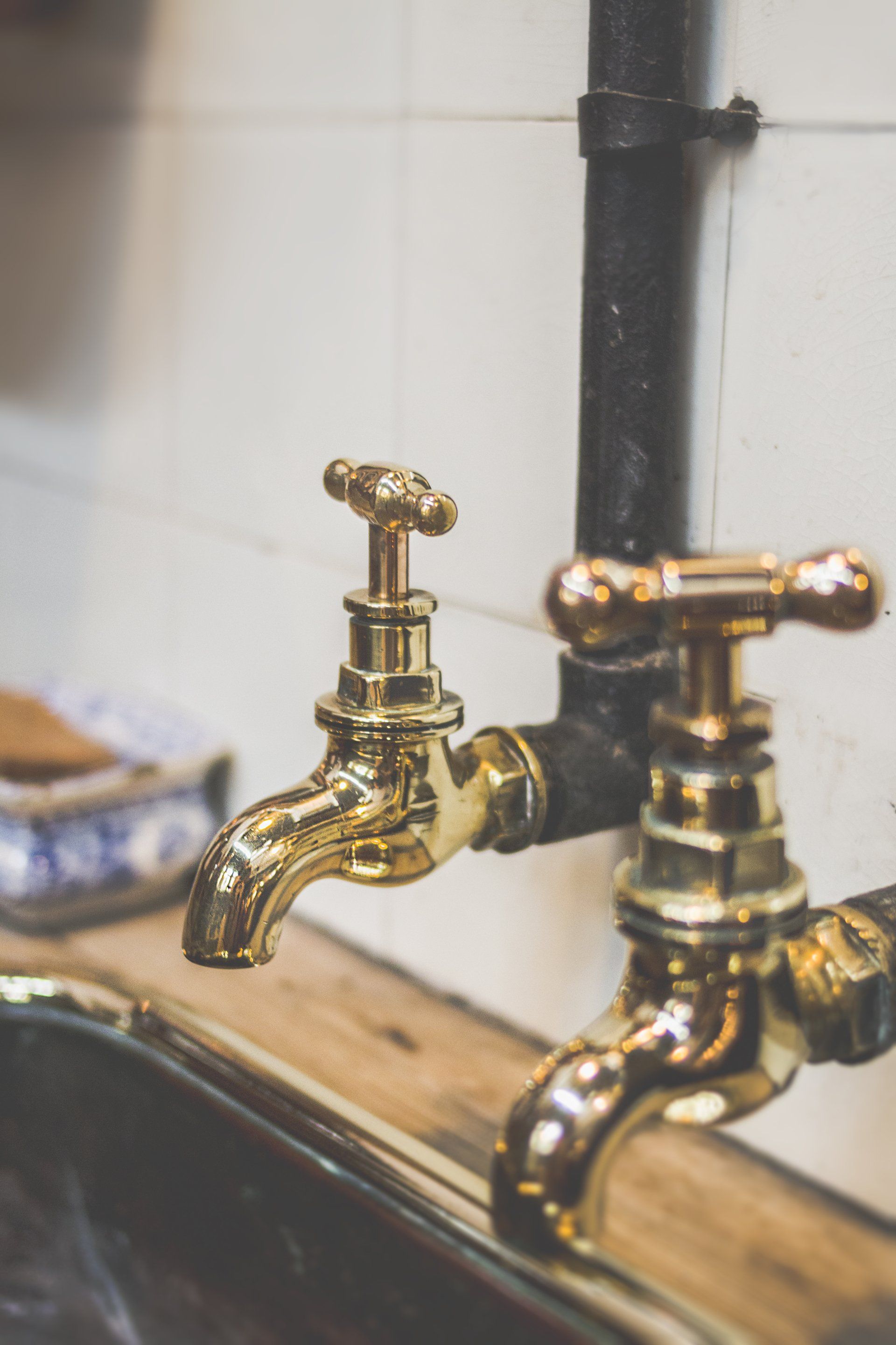 a pair of brass faucets on a kitchen sink