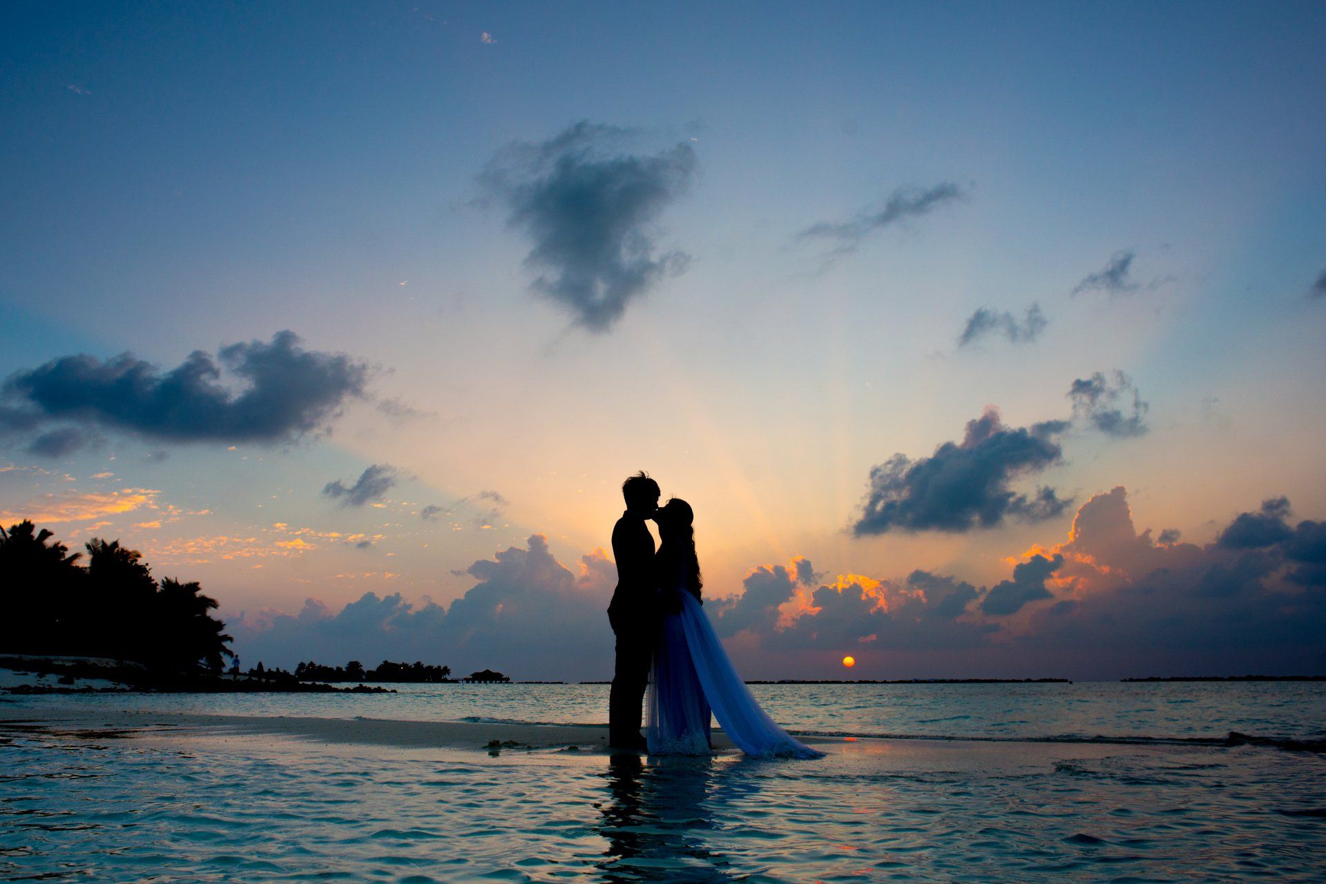 couple on honeymoon kissing on the beach
