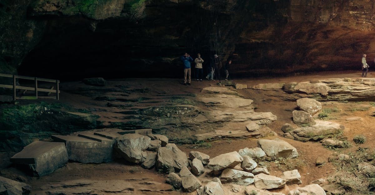 a group of people are standing in a cave .