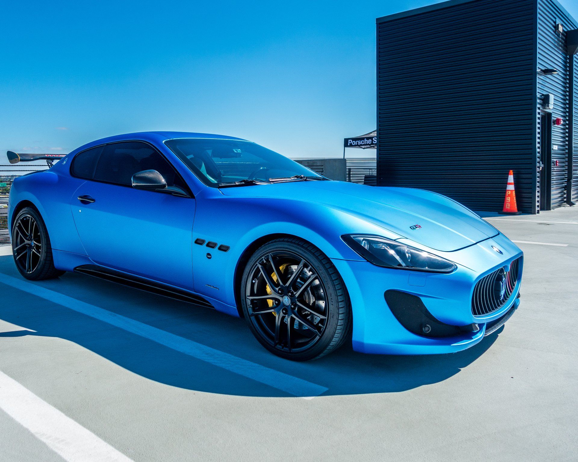 A blue maserati is parked in a parking lot