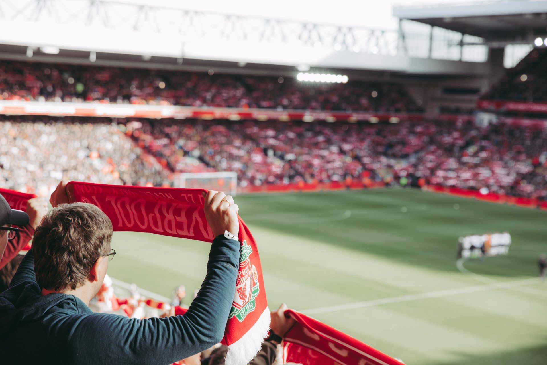 A man is holding a scarf in a soccer stadium.