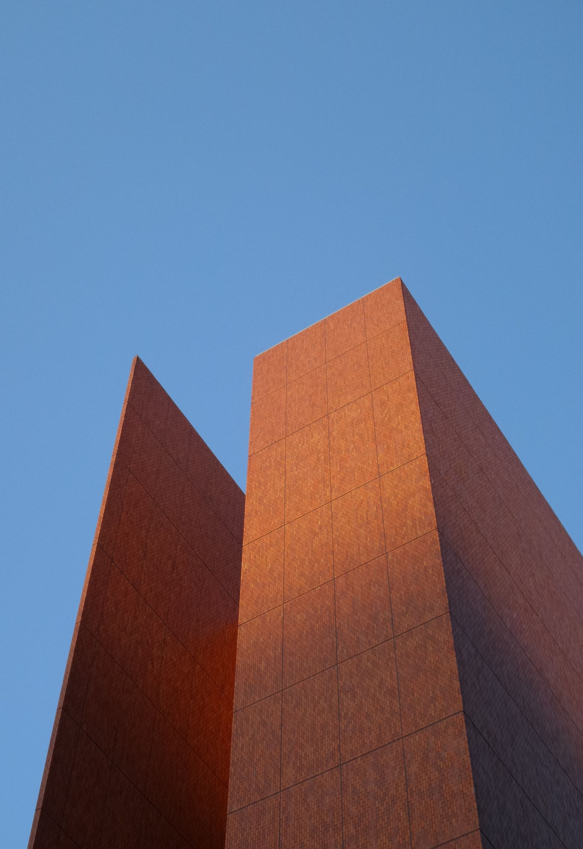 Looking up at a tall building with a blue sky in the background