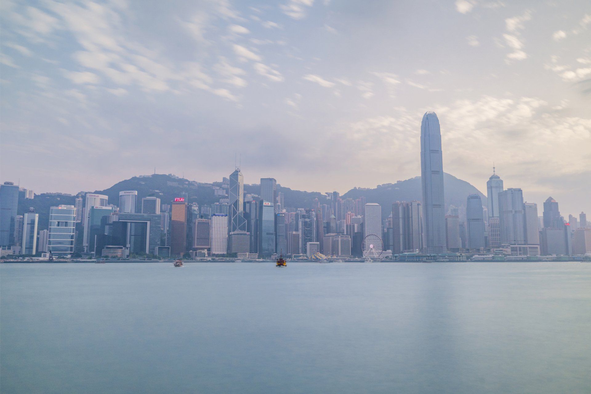 The skyline of hong kong is visible from the water.