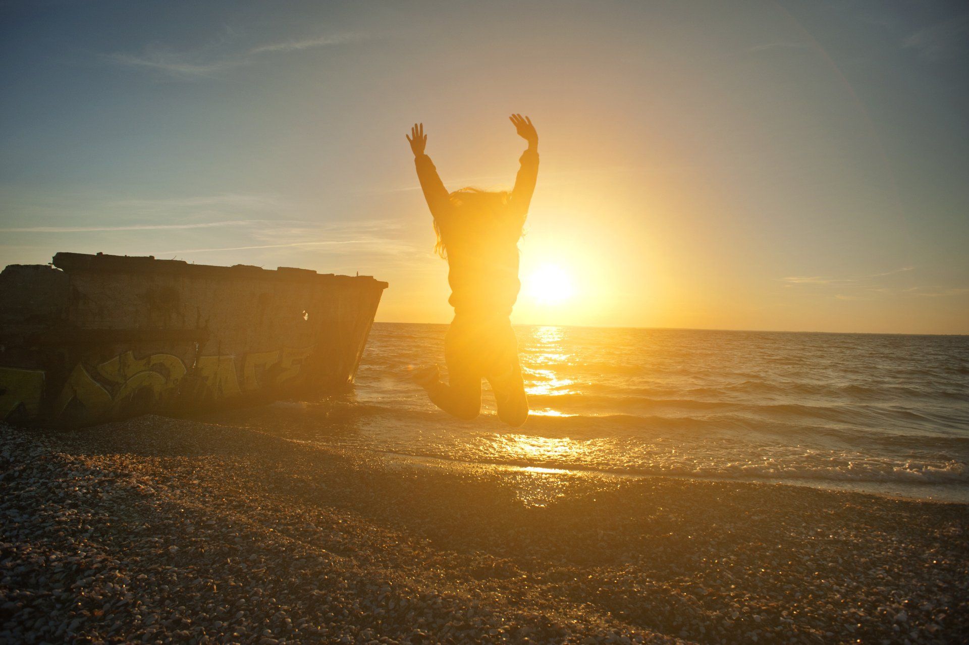 Springede vrouw in de avondzon aan het strand