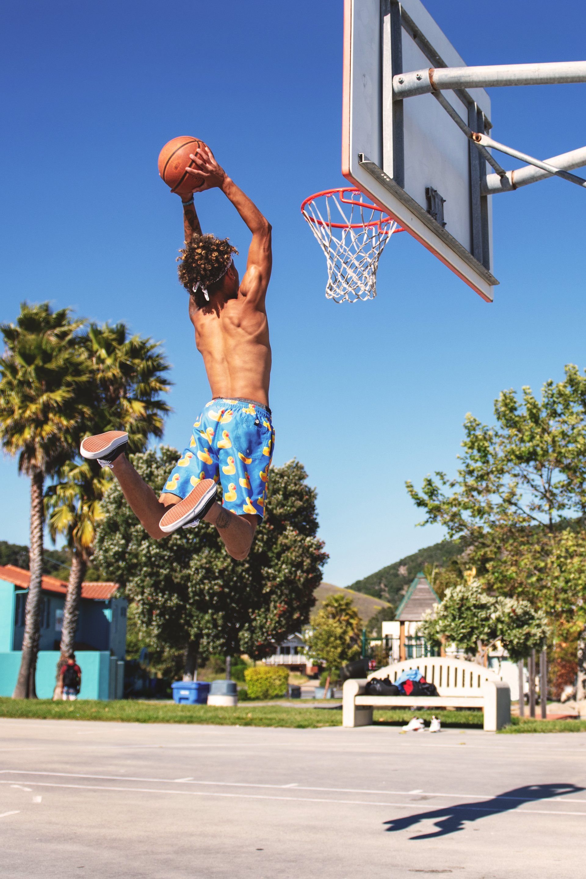 A man is jumping in the air to dunk a basketball into a hoop.
