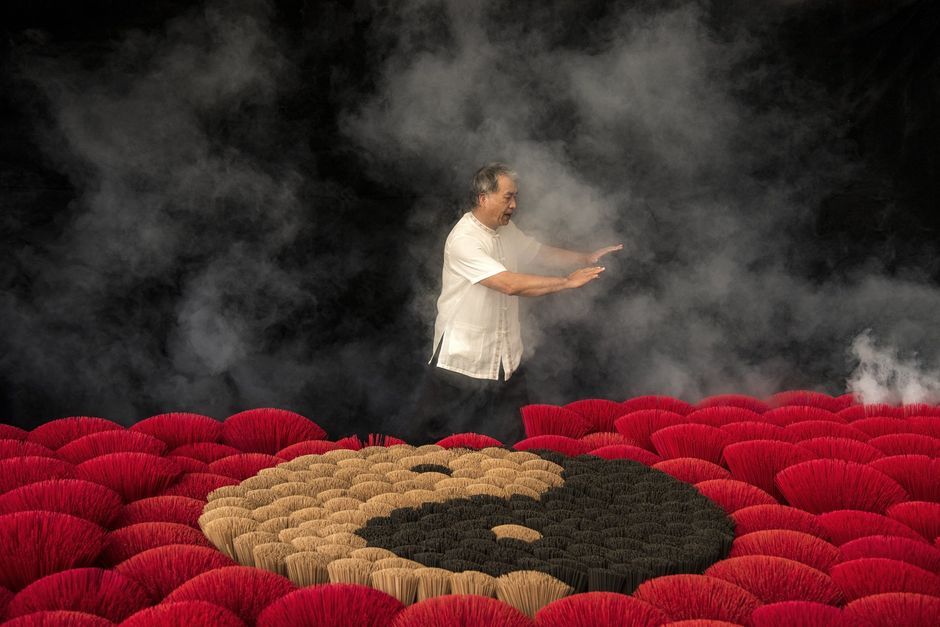 Man practicing Qigong in front of a yin-yang flower bed at Chi Energy in Venice, Florida