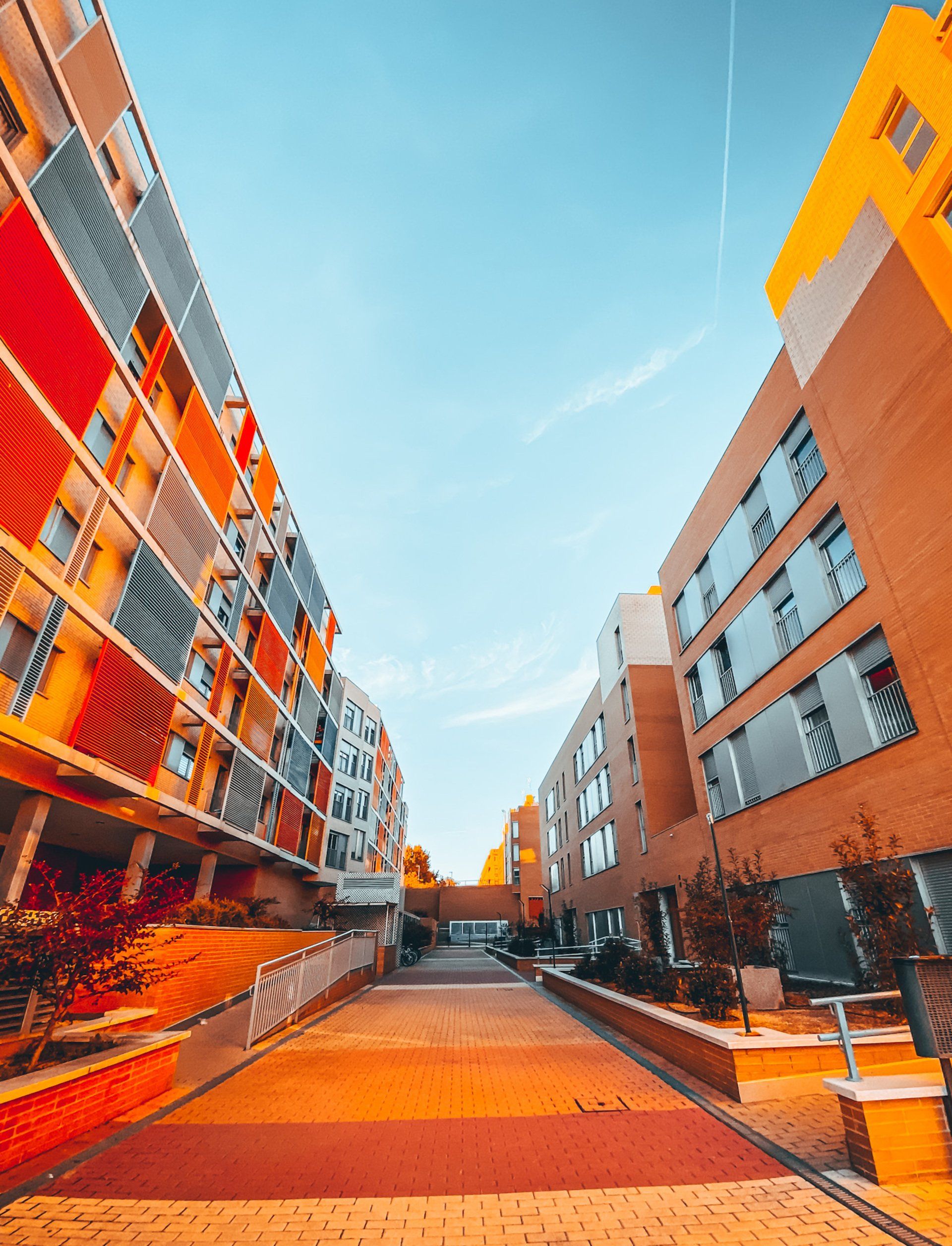 A street between two buildings with a blue sky in the background.