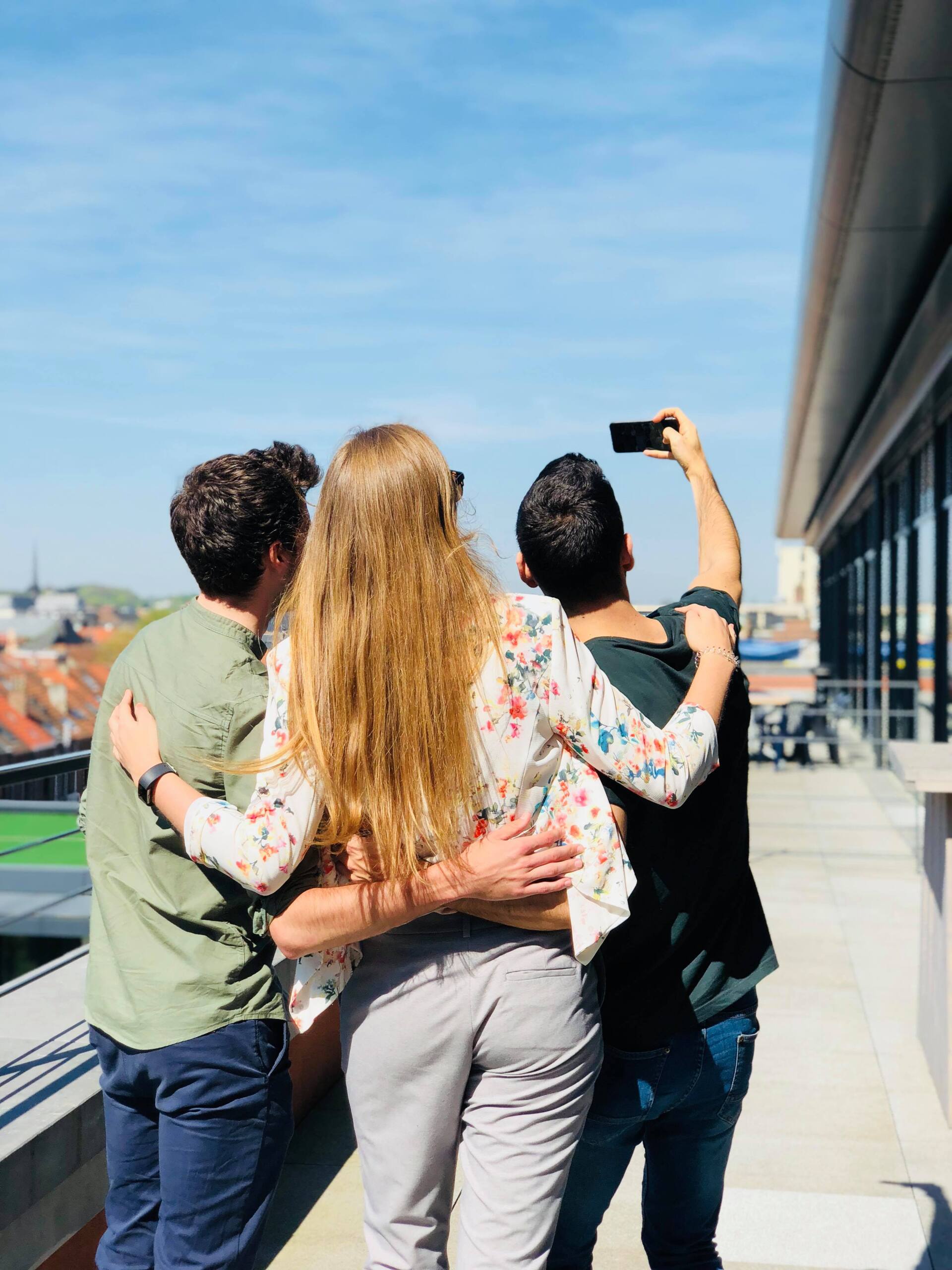 A man is taking a picture of his friends on a rooftop