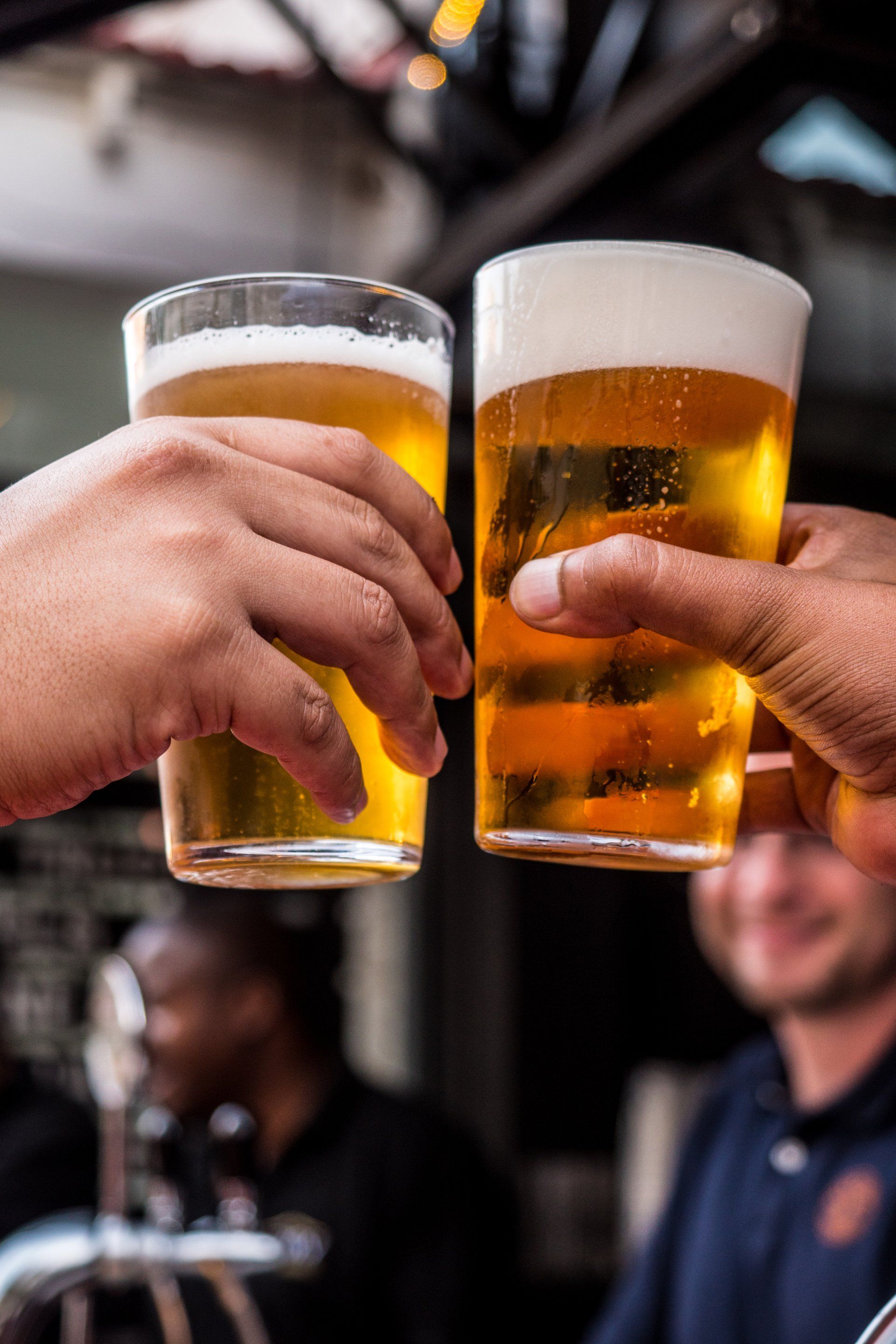 2 people clinking beer glasses.