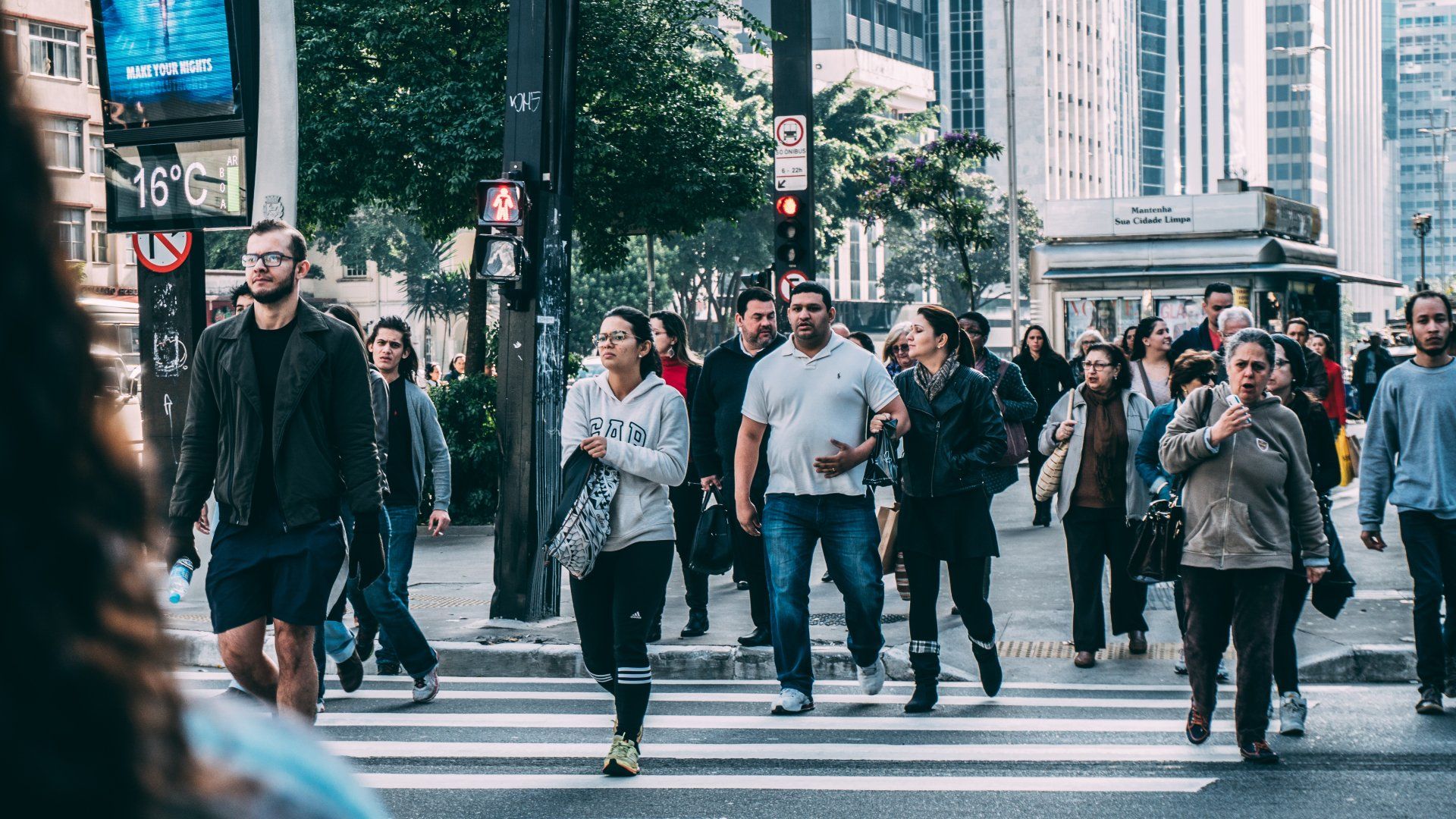 a large group of people are crossing a street in a city .