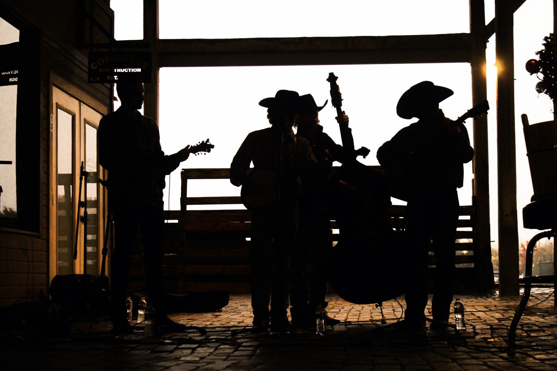 A group of people are playing instruments on a porch.