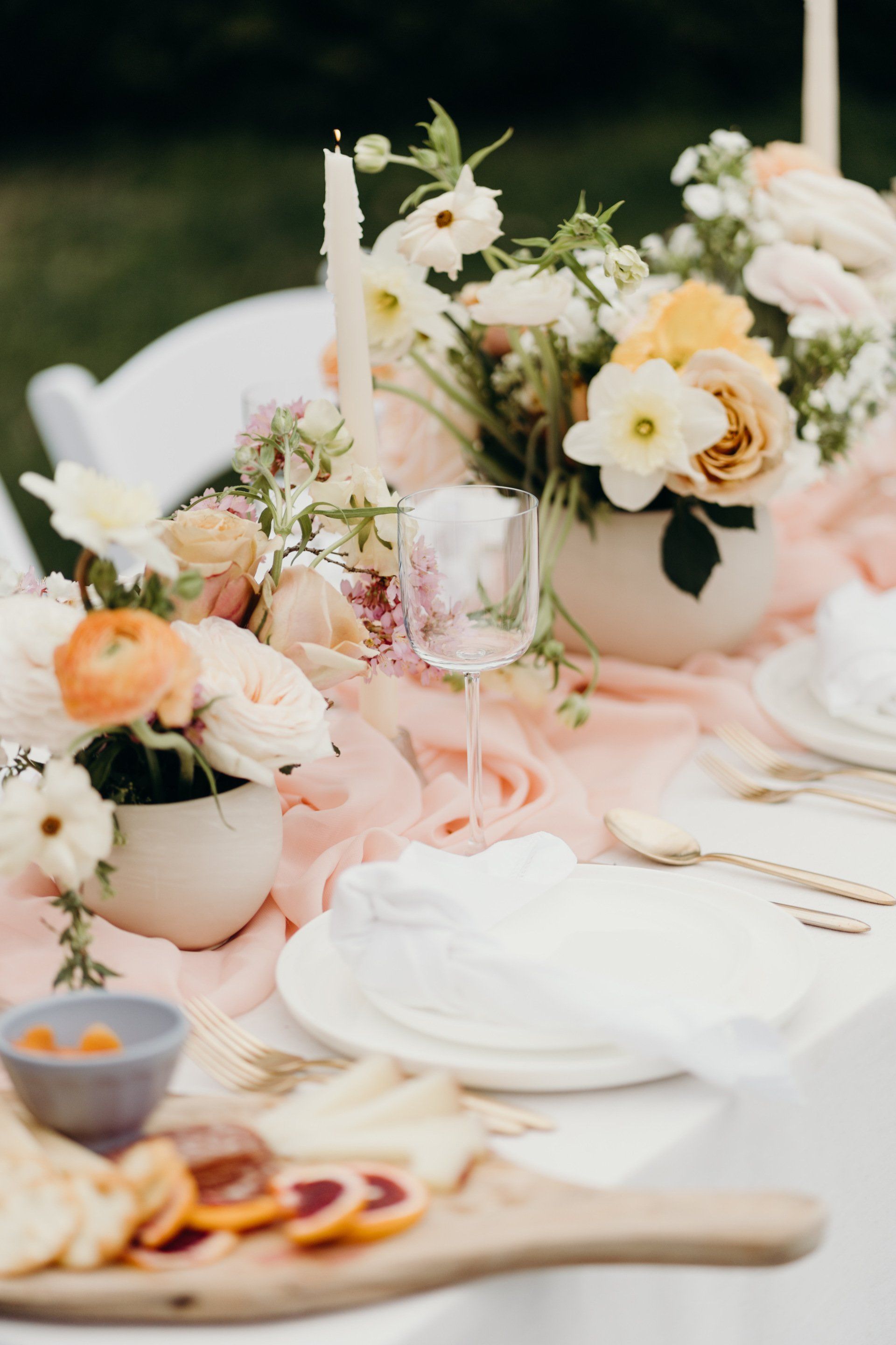 A table with plates, utensils, and flowers on it.