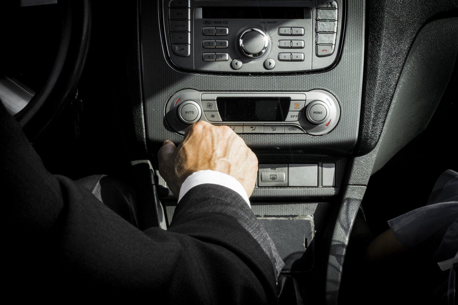 chauffeur with his hand on comfort control in suv