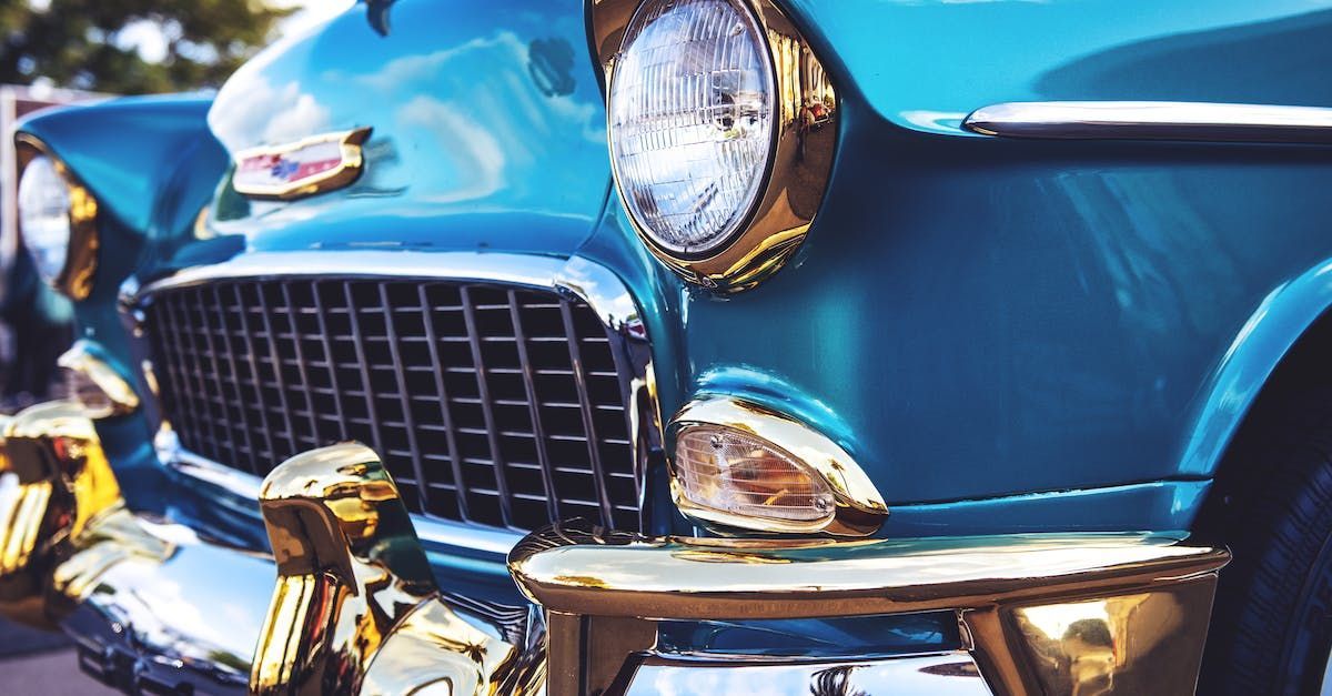 A close up of the front of a blue car with gold trim.