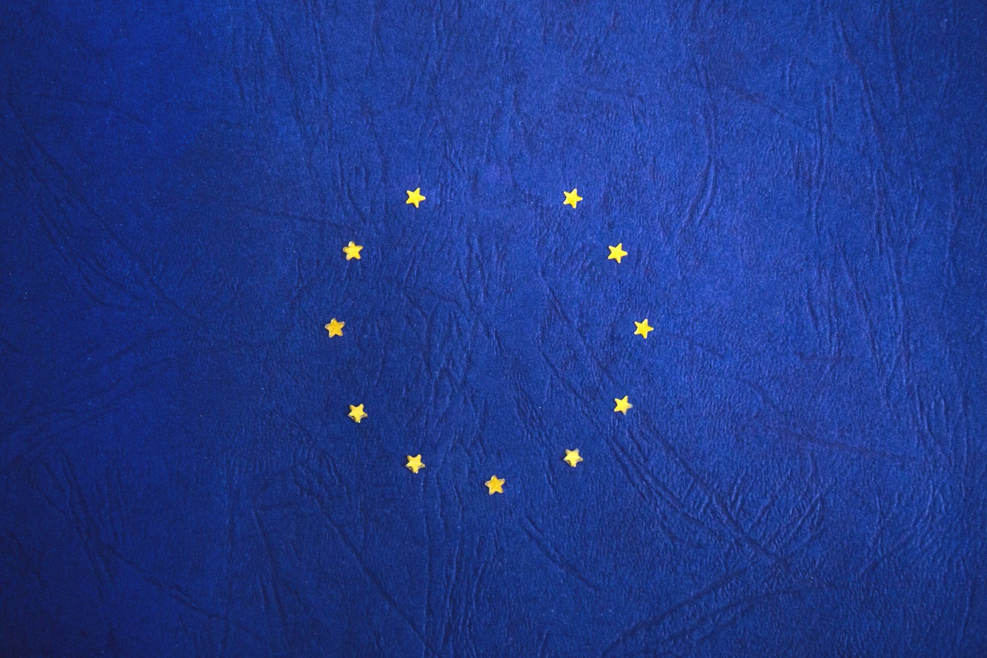 a blue background with a circle of yellow stars on it 