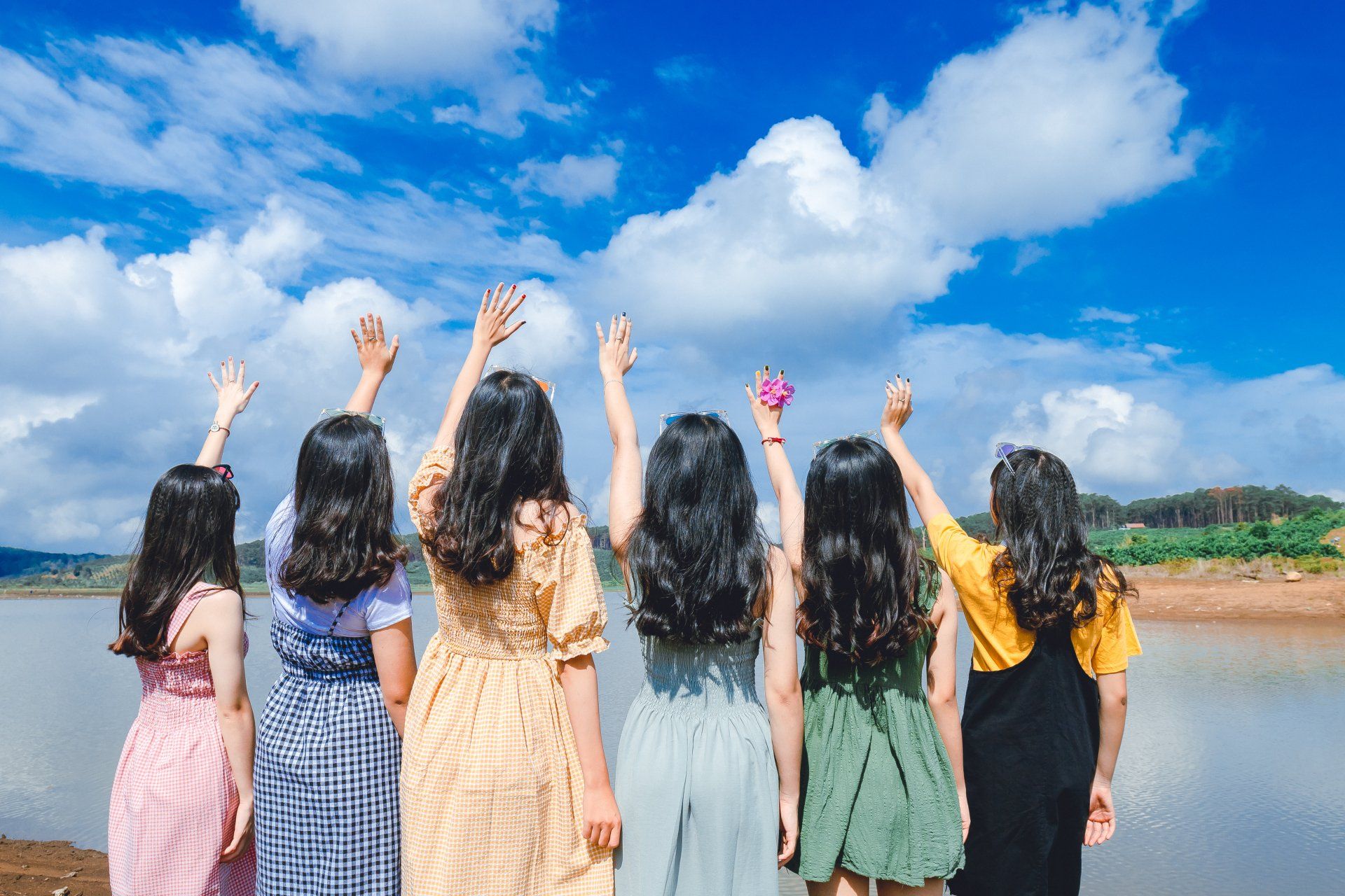 A group of young women are standing next to each other with their arms in the air