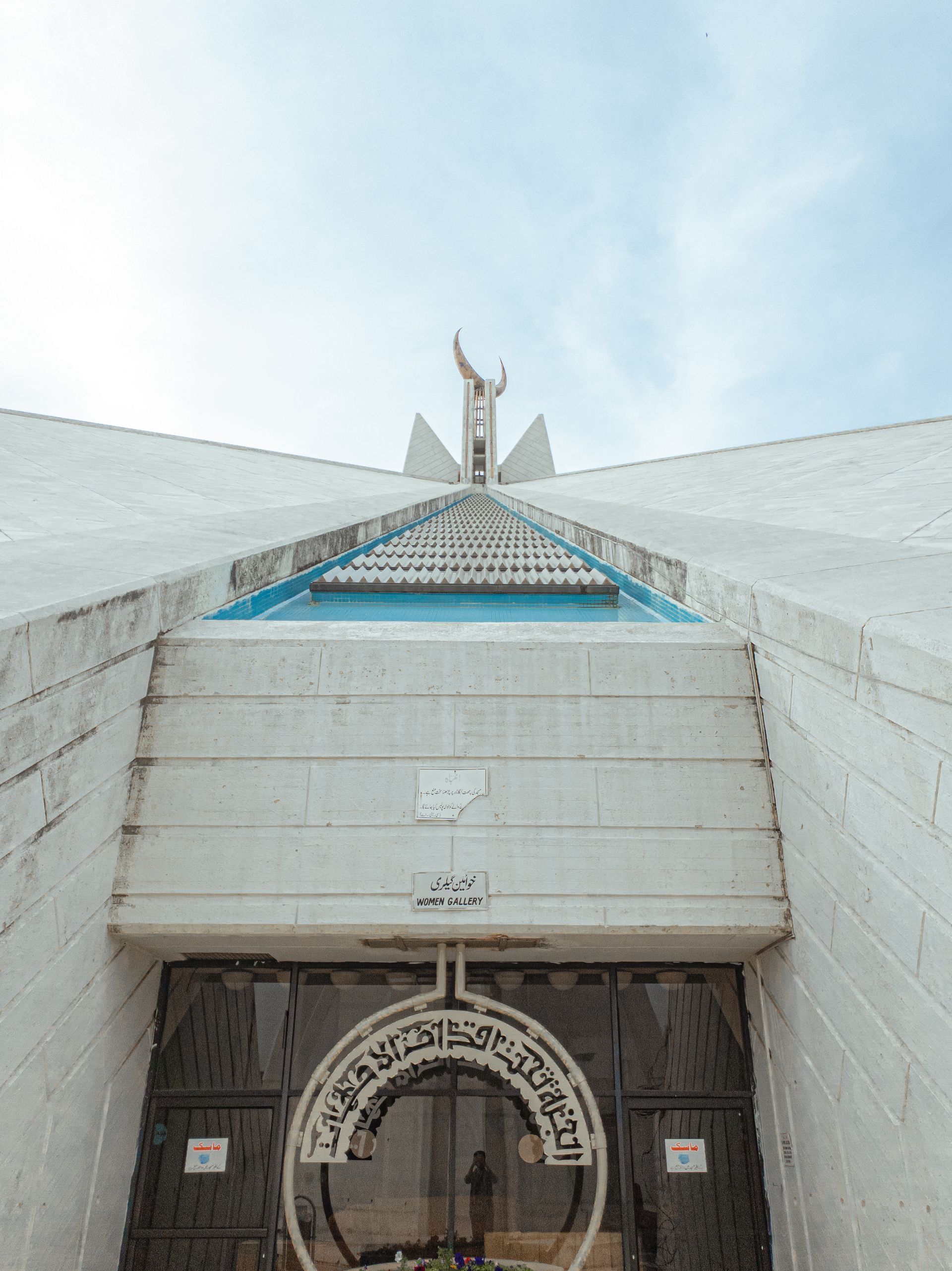 The entrance to a building with a statue on top of it.