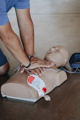 photo of person doing CPR compressions on a practice dummy