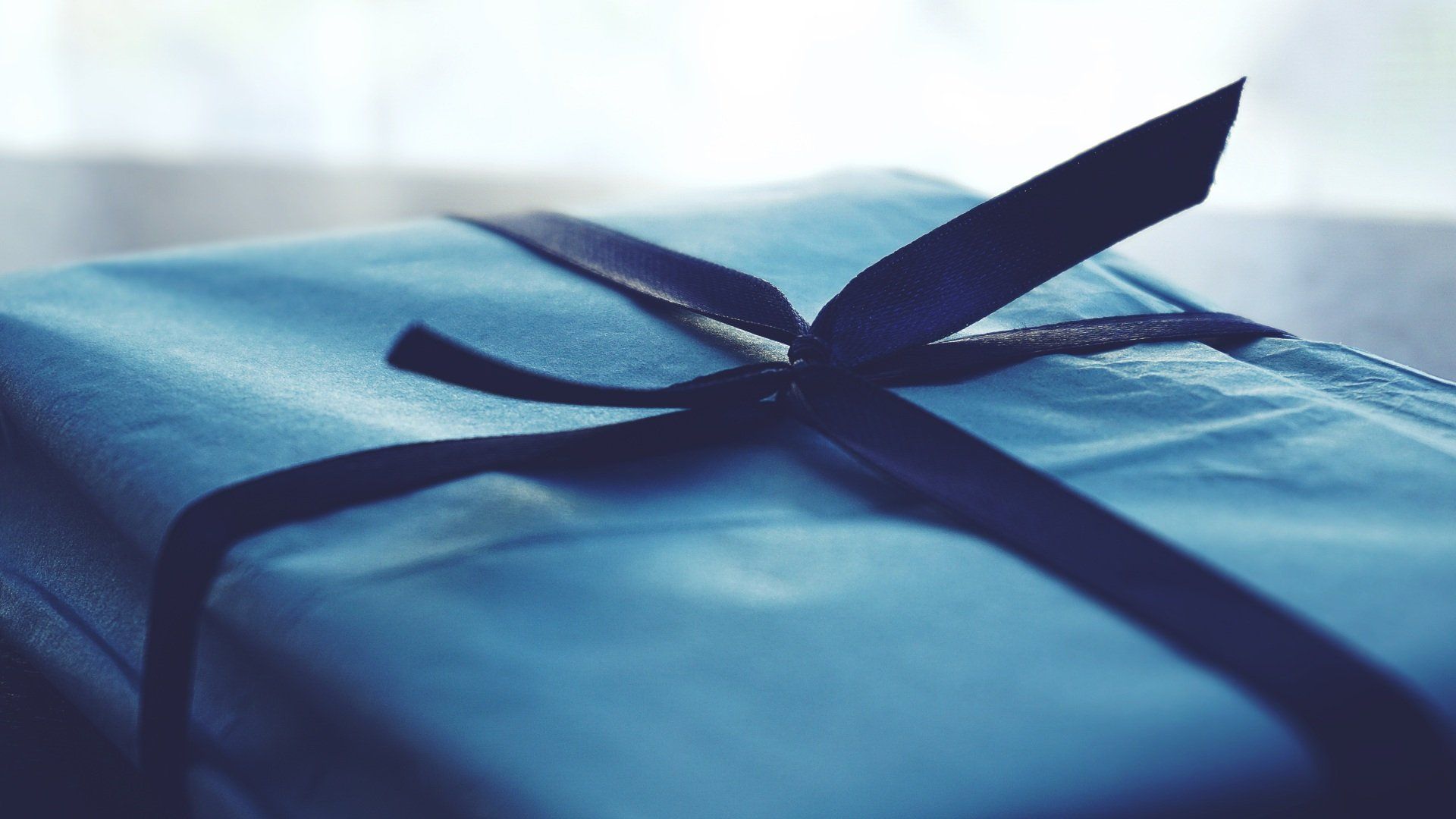 A light blue present with a dark blue ribbon