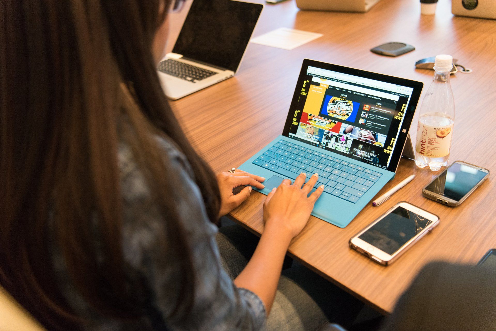 A woman is sitting at a table using a laptop computer.
