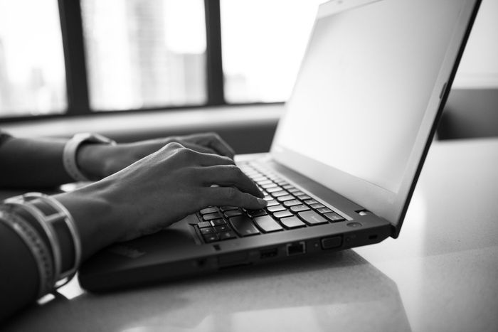 Woman typing at a laptop