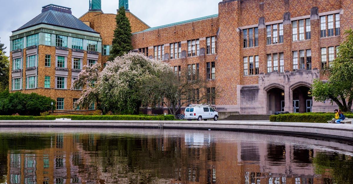 A large brick building with a pond in front of it.