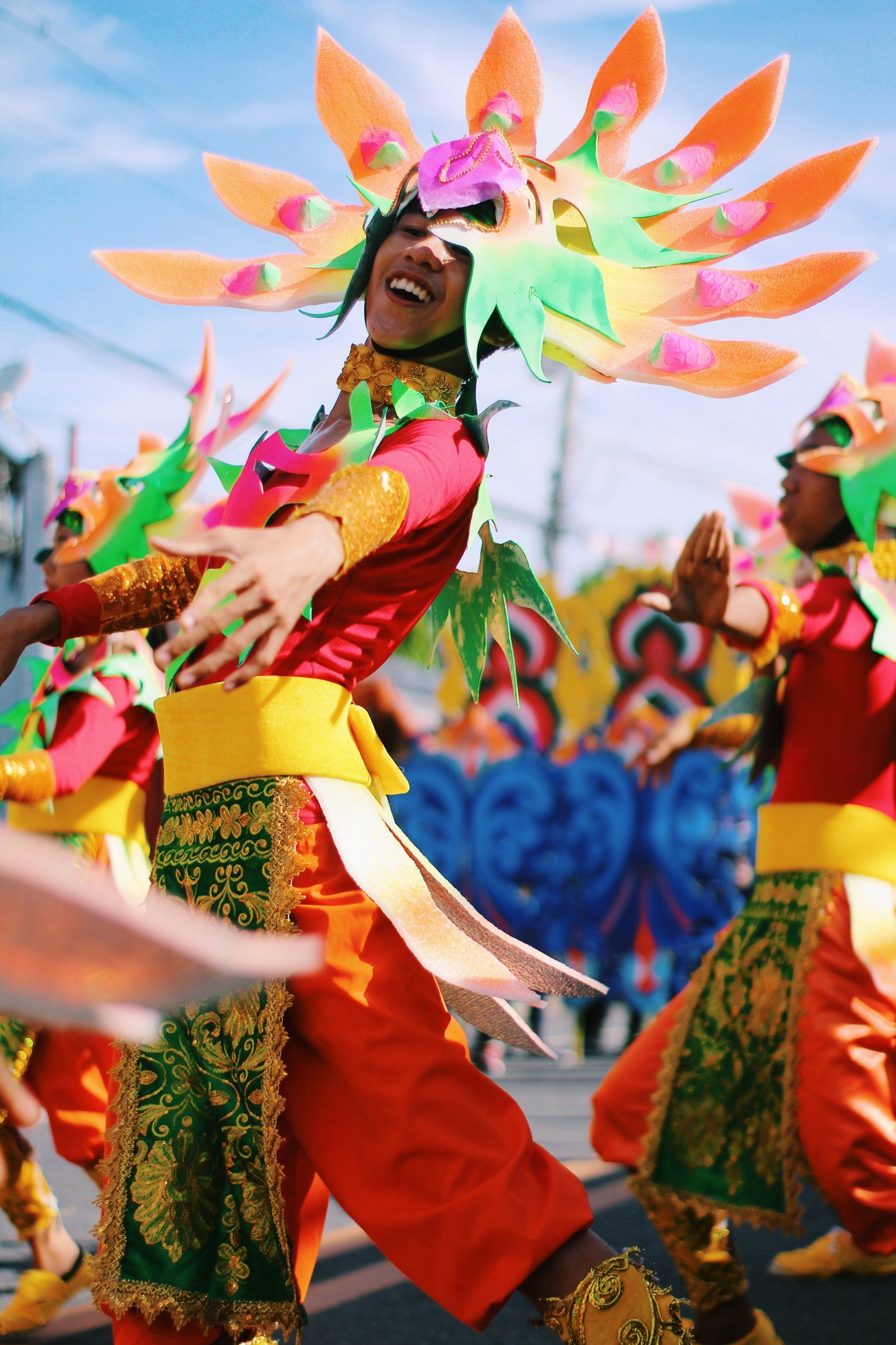 A festival outside with dancers in colored costumes
