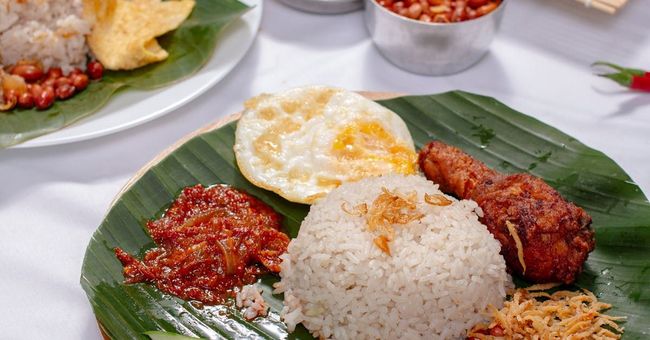 A plate of fragrant nasi lemak with sambal, featuring fluffy coconut rice topped with spicy sambal sauce