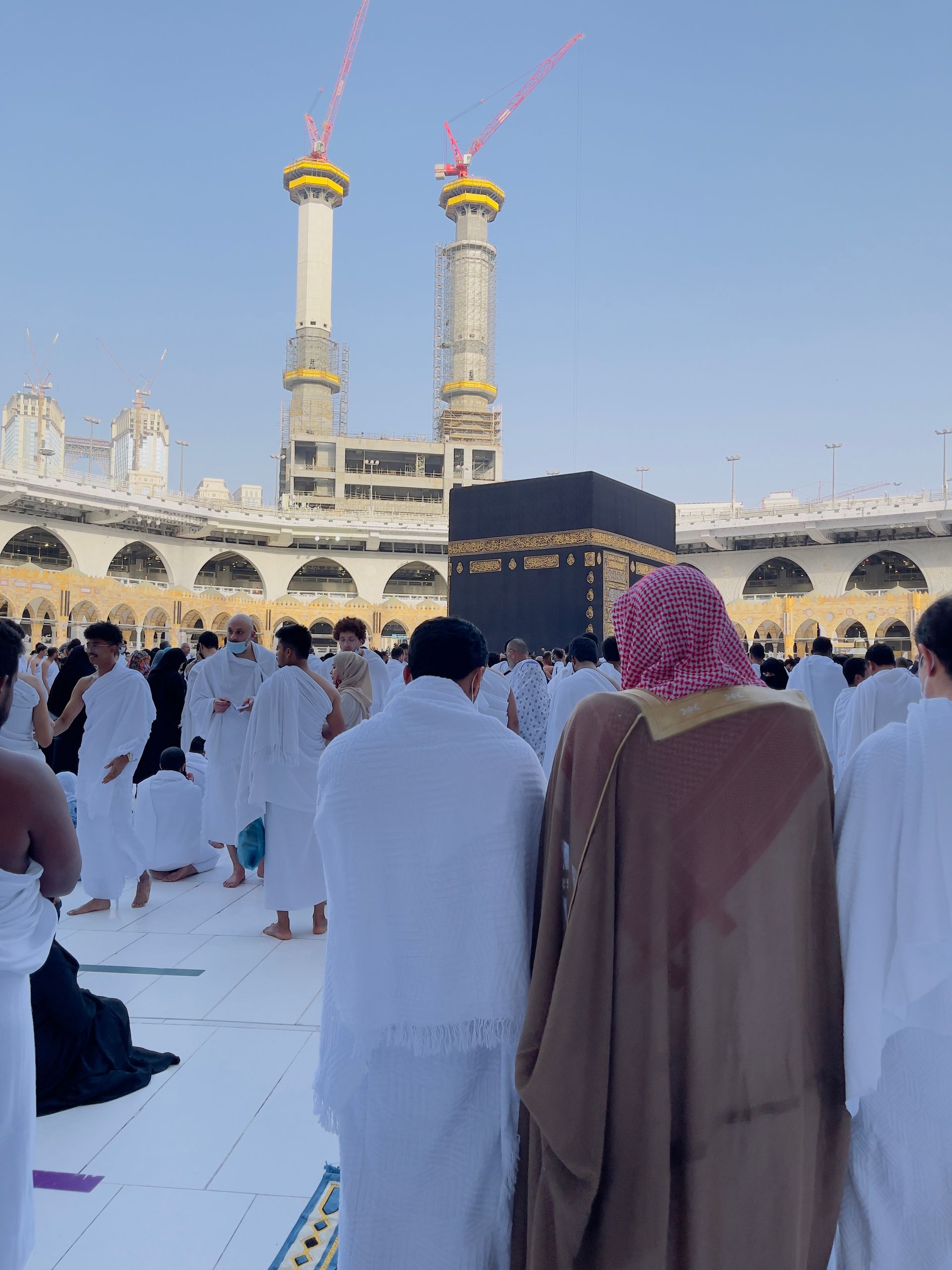A group of people are standing in front of a mosque.