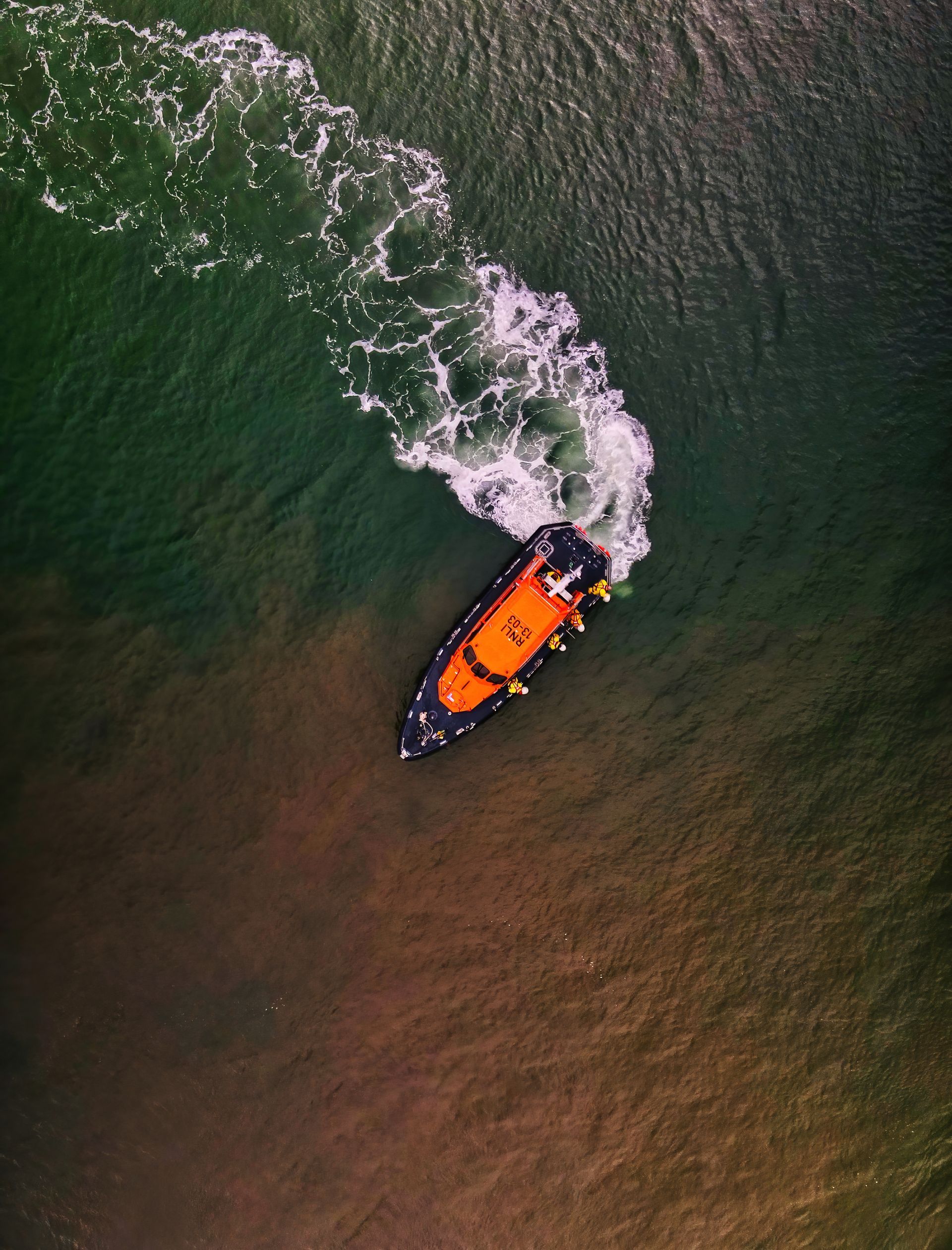 An aerial view of a rescue boat floating on top of a body of water.