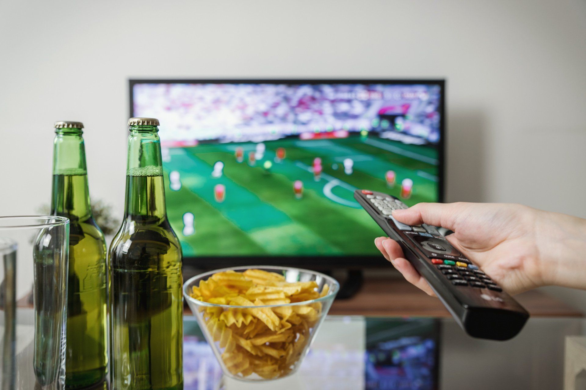 a person is holding a remote control in front of a television .