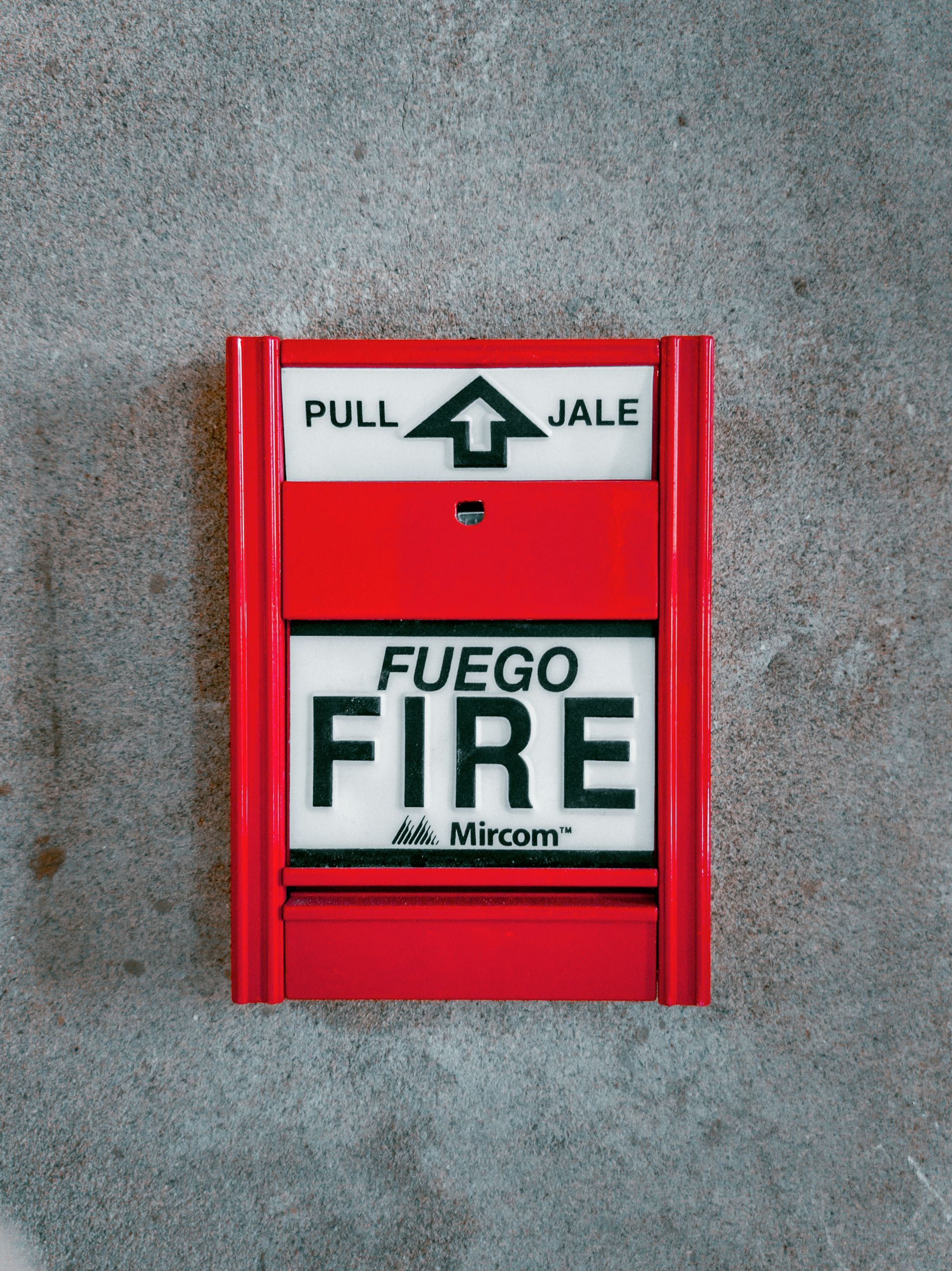 A red fire alarm that says fuego fire on it