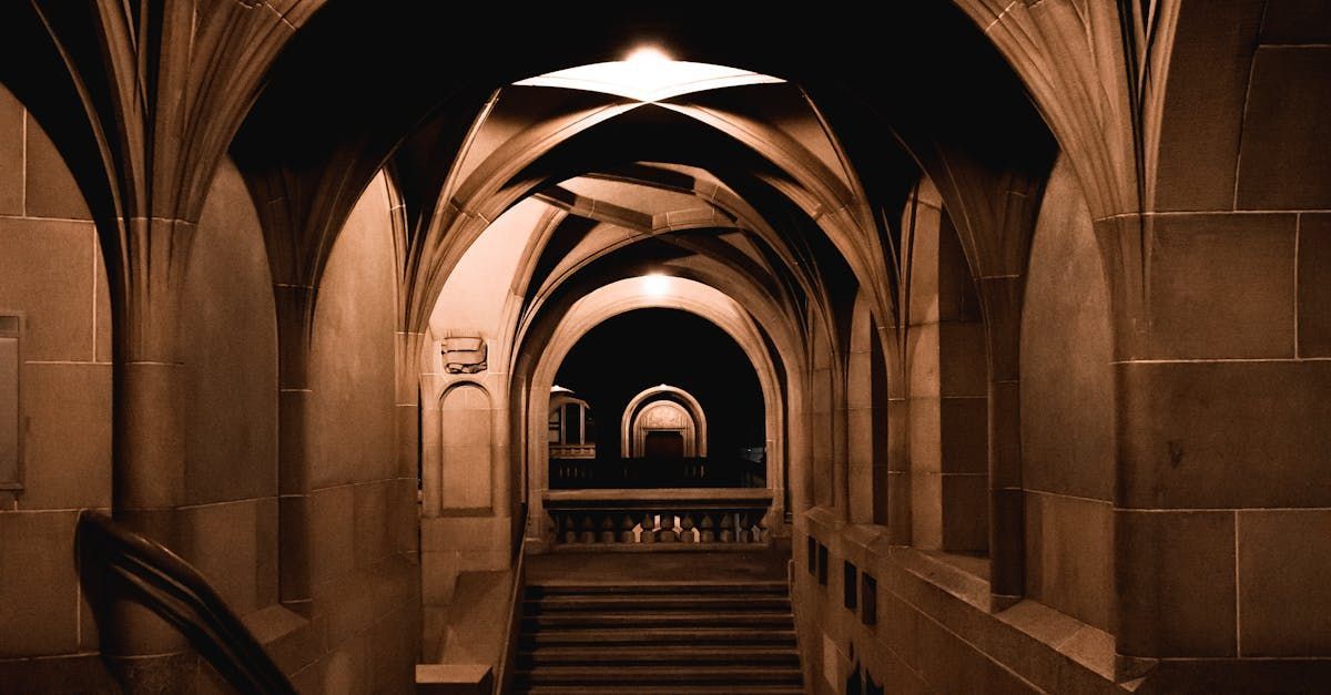 A long hallway with arches and stairs in a building