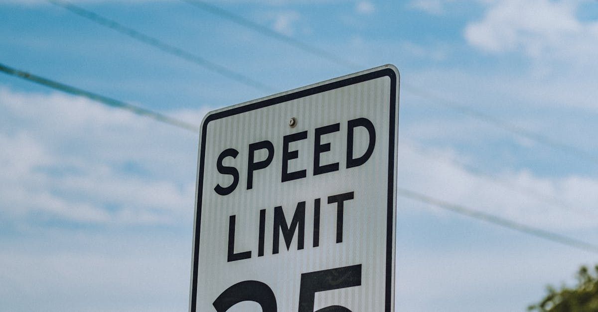 A speed limit sign with a blue sky in the background.