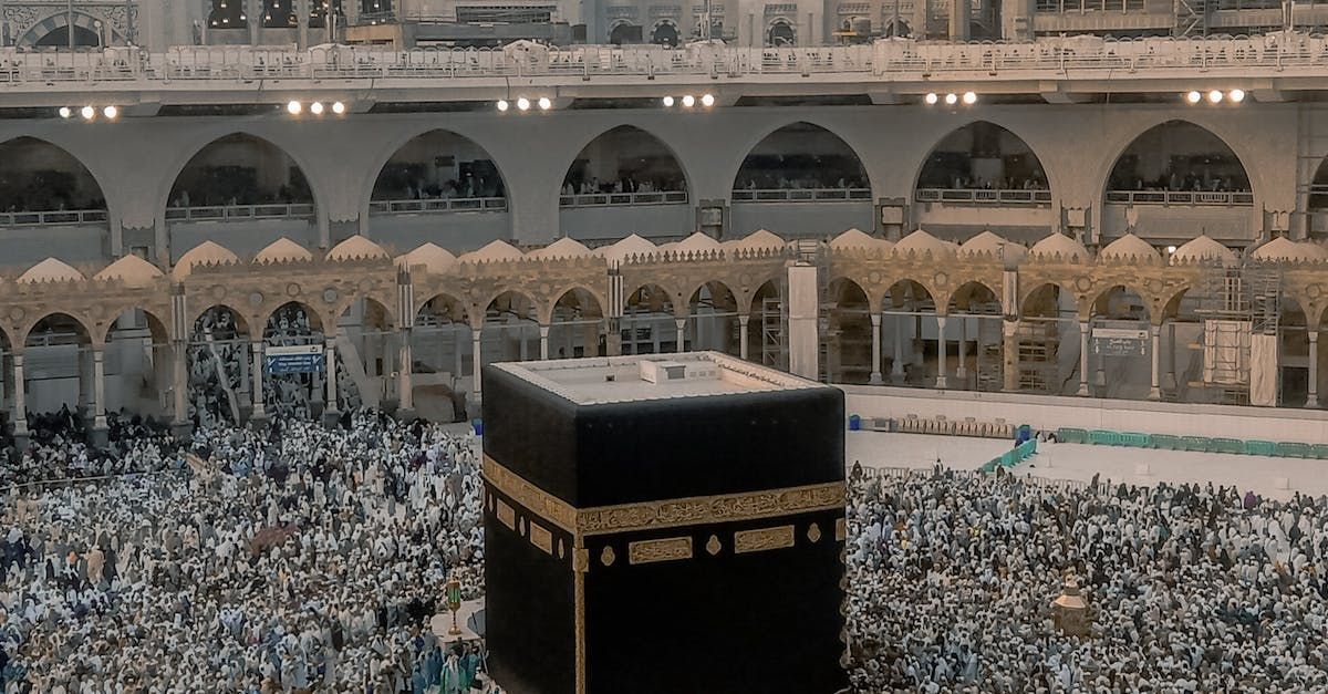 A large group of people are gathered around the kaaba in a mosque.