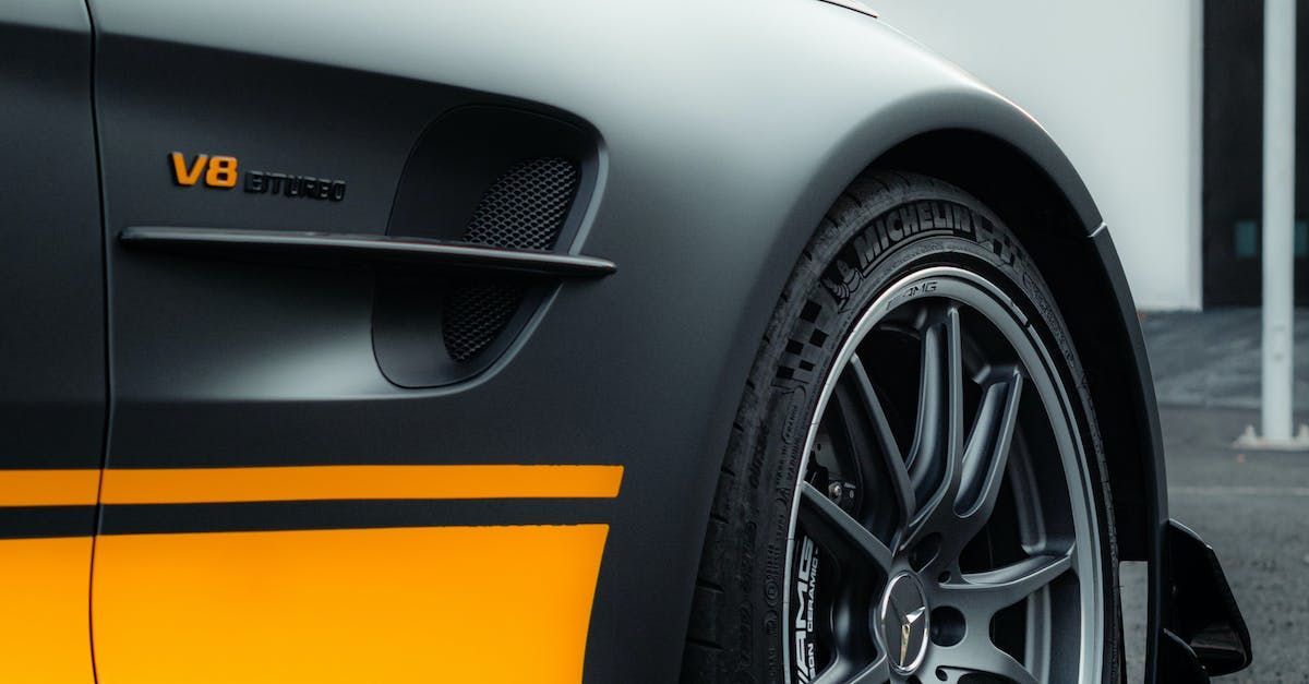 A close up of the side of a black and yellow matte finished sports car .