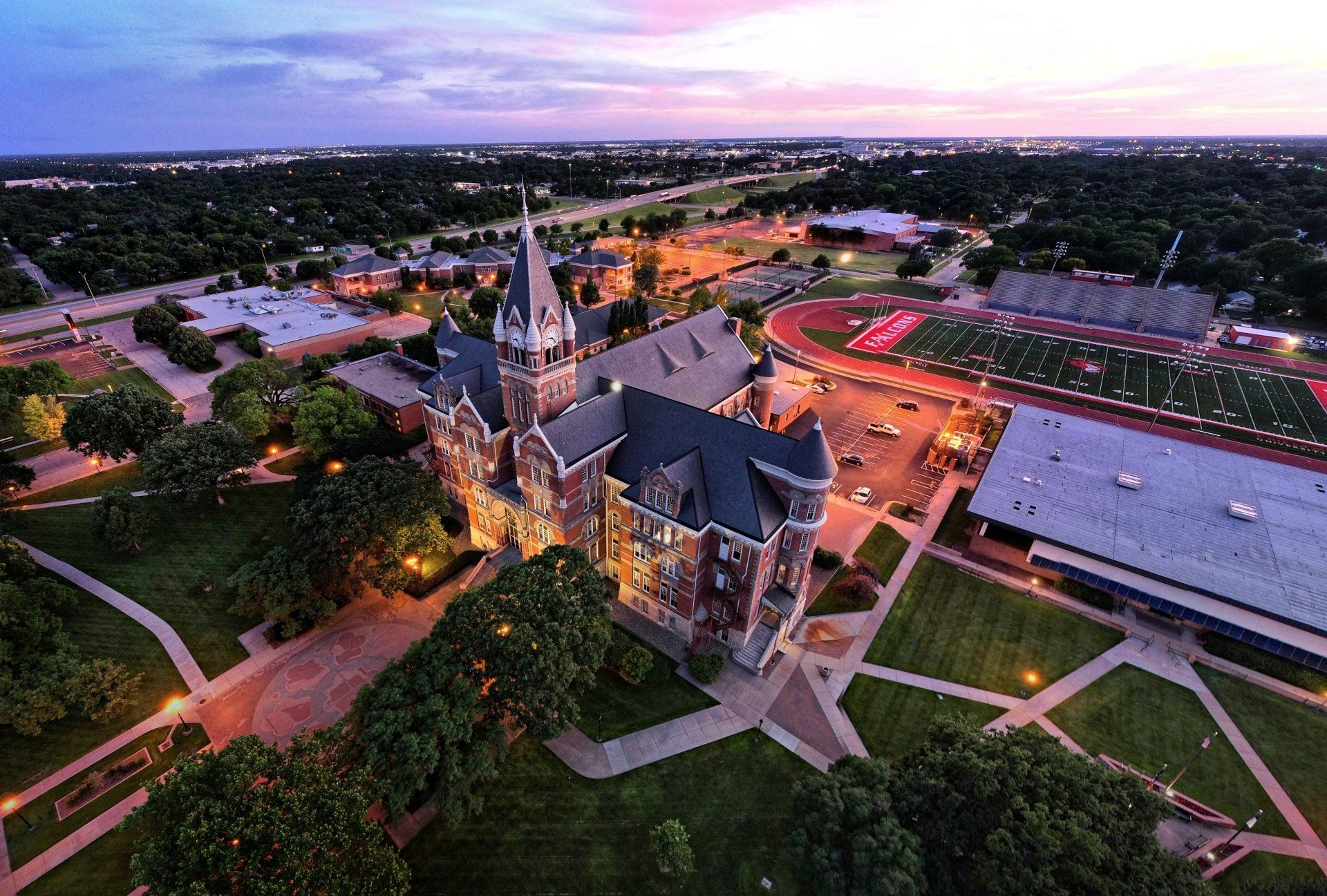 an aerial view of a large building on a college campus at night .