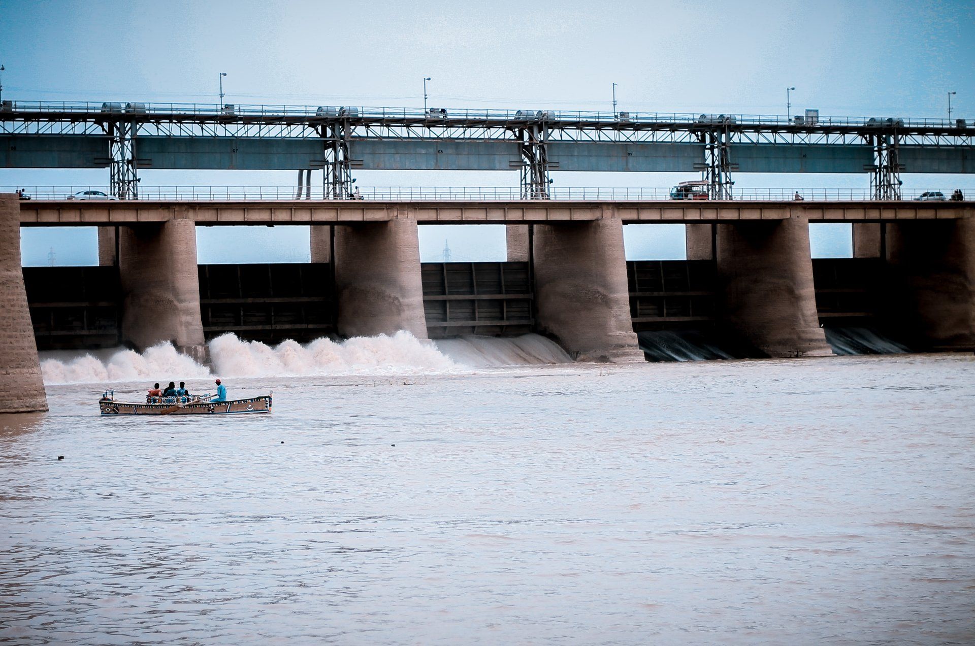 A boat is going under a bridge over a body of water