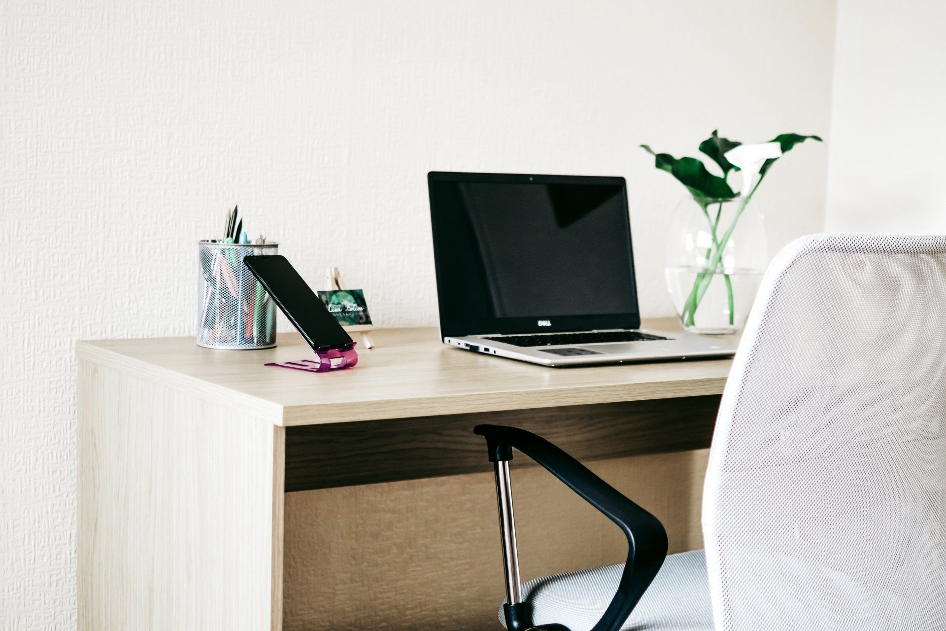 A desk with a laptop and a cell phone on it