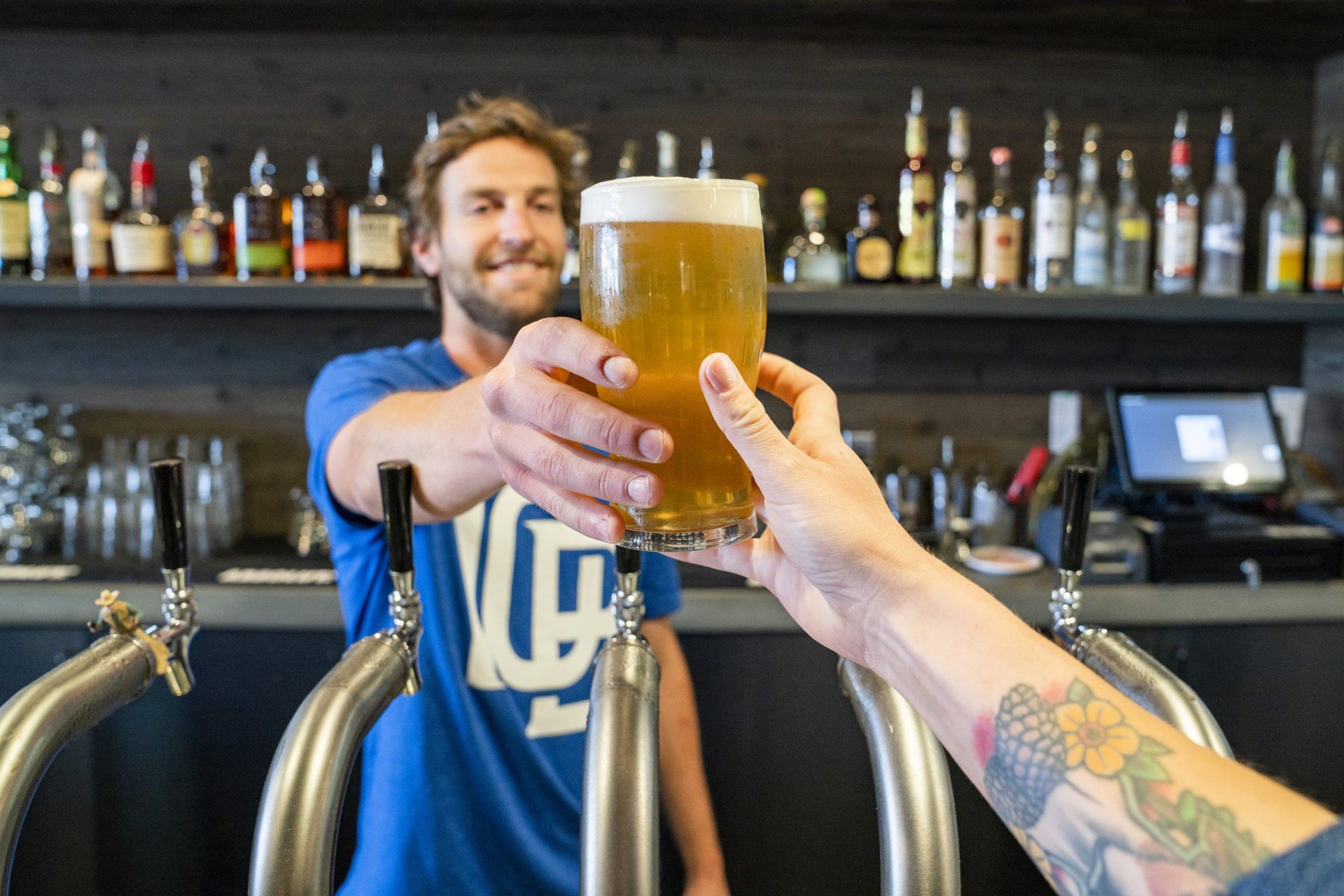 a man is pouring a glass of beer into another man 's hand .