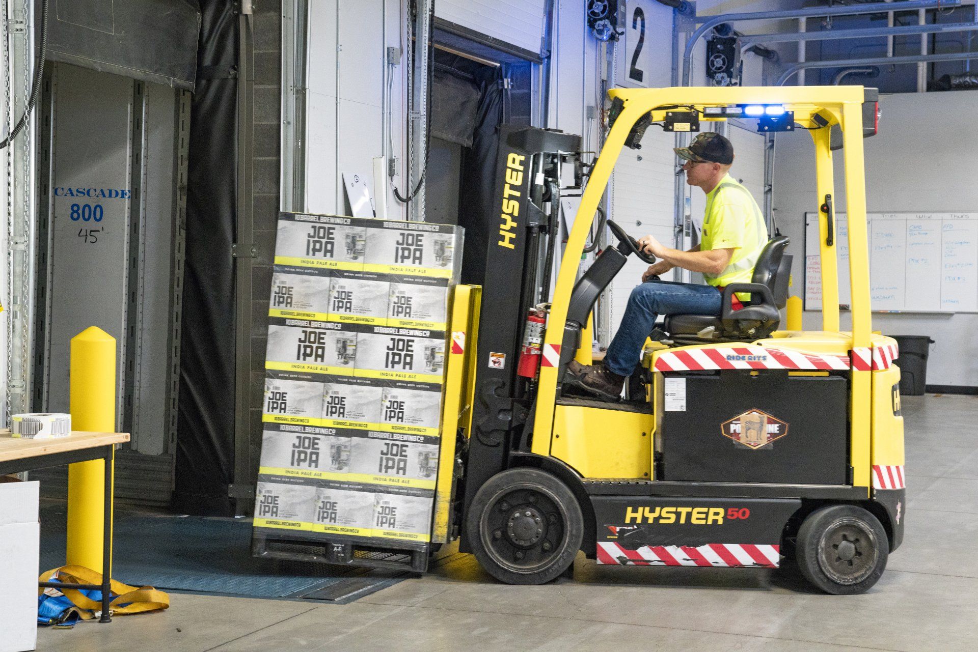 A forklift carrying a pallet of drinks