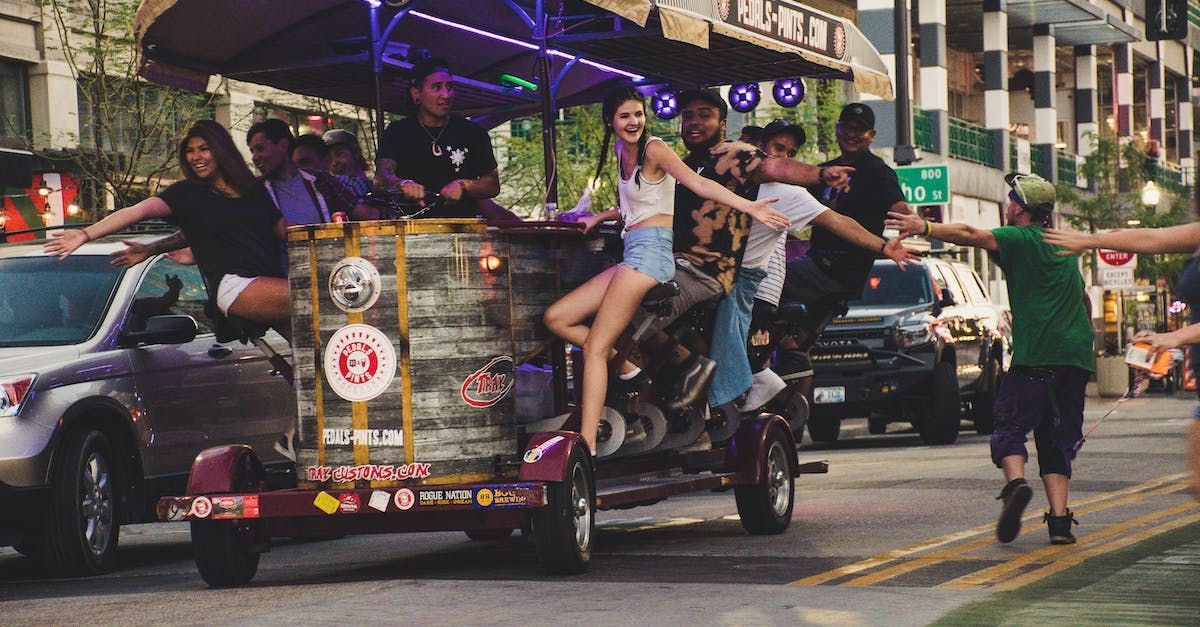 a group of people are riding a bike on a trailer down a city street . Barter's Travelnet 