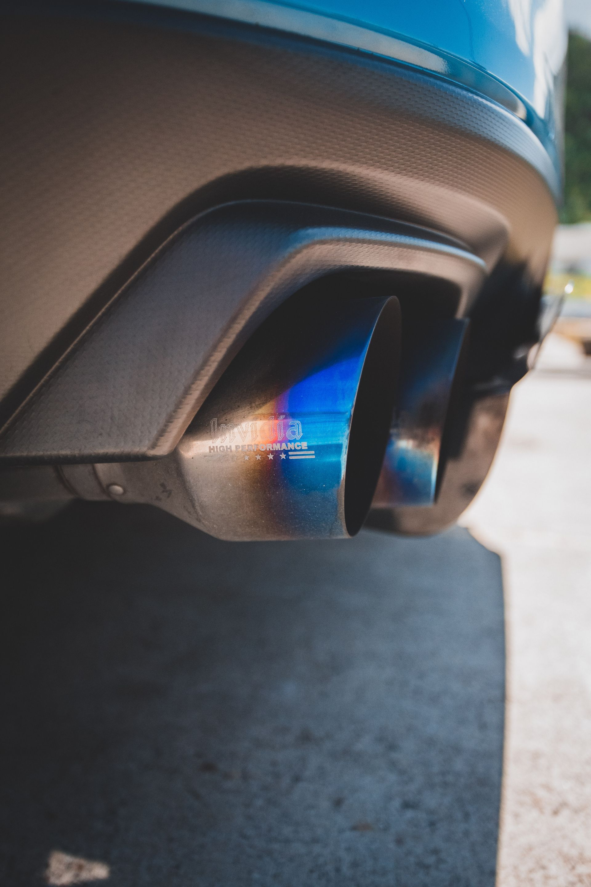 A close up of the exhaust pipe of a blue car. | Diamond Family Auto Service