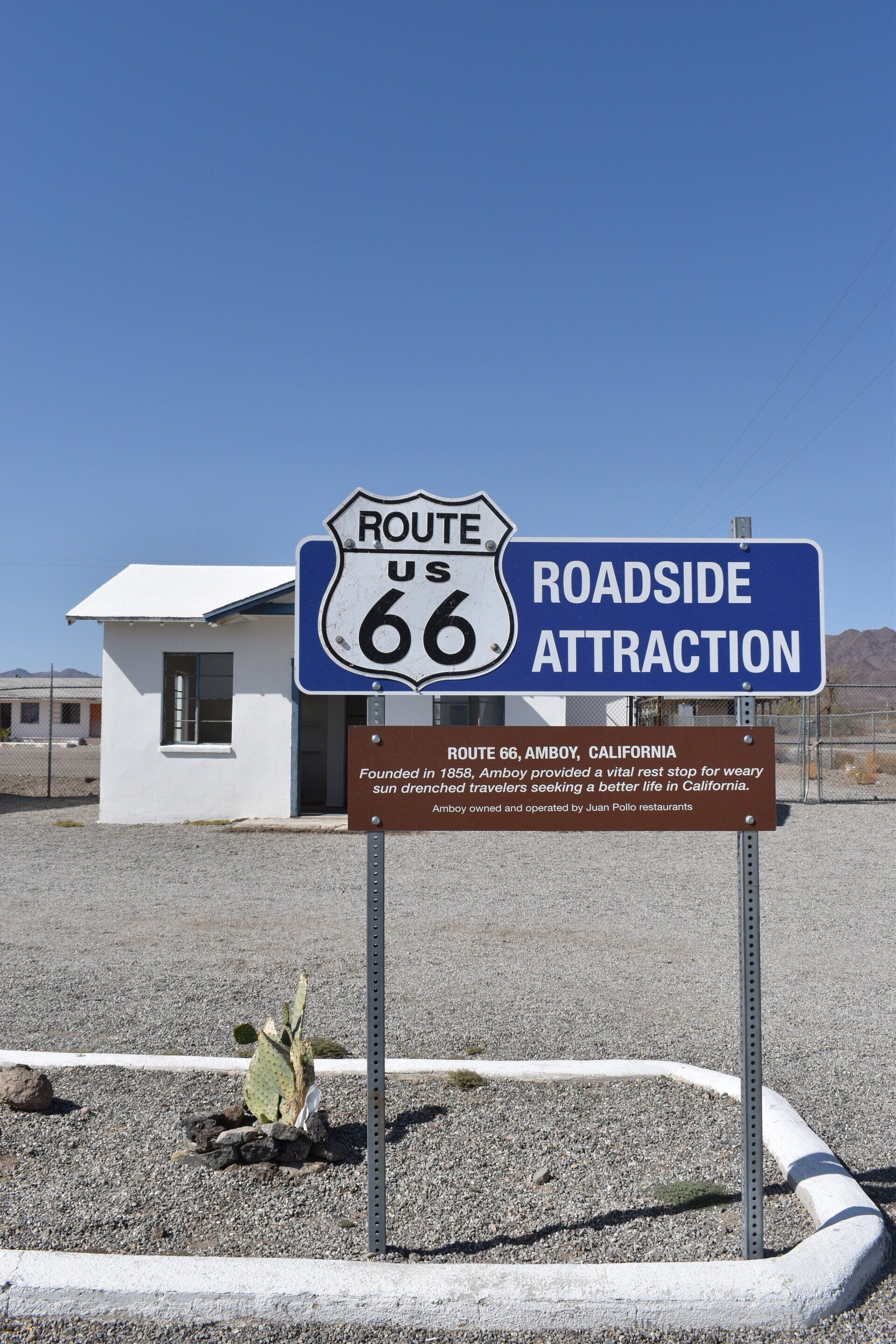 A blue sign for route 66 roadside attraction