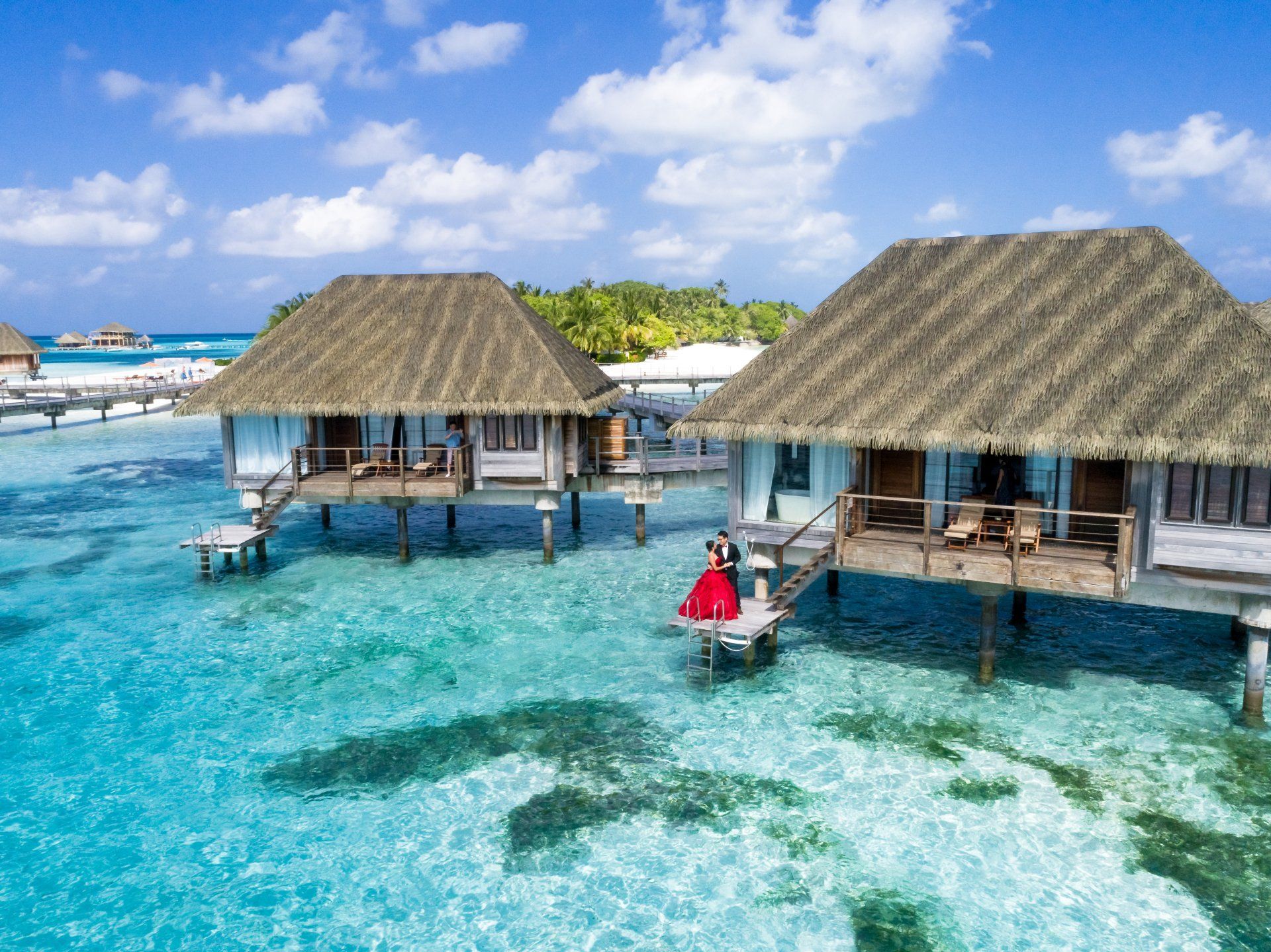 A couple of houses on stilts in the middle of the ocean.